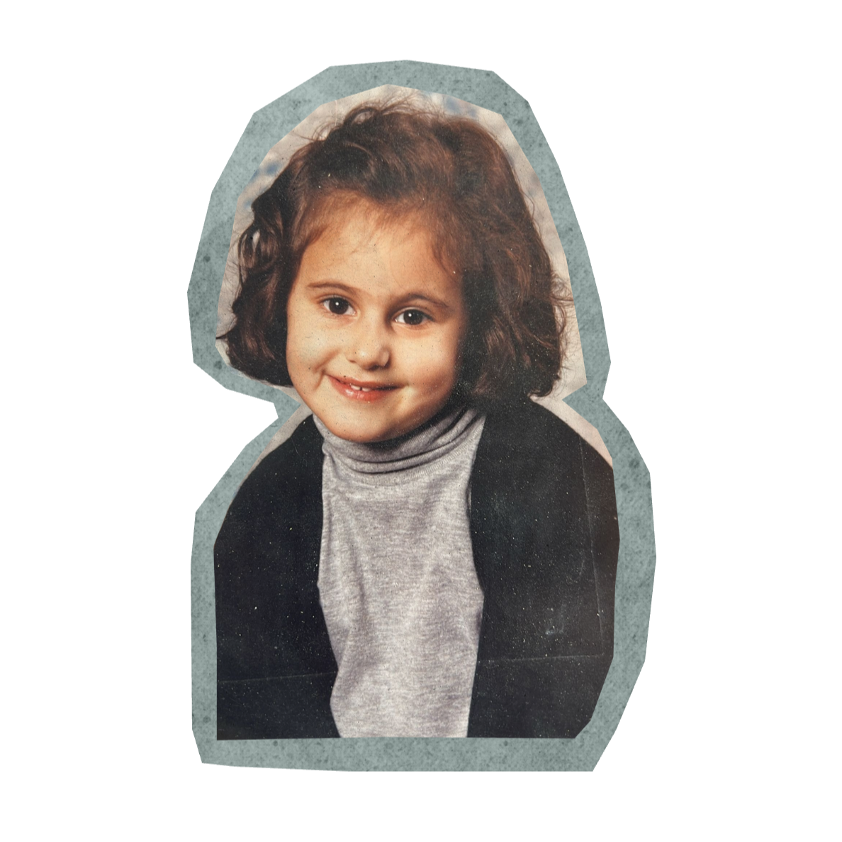 A young girl with curly brown hair, smiling, wearing a gray turtleneck and black jacket. The photo appears to be a childhood portrait with a textured background.