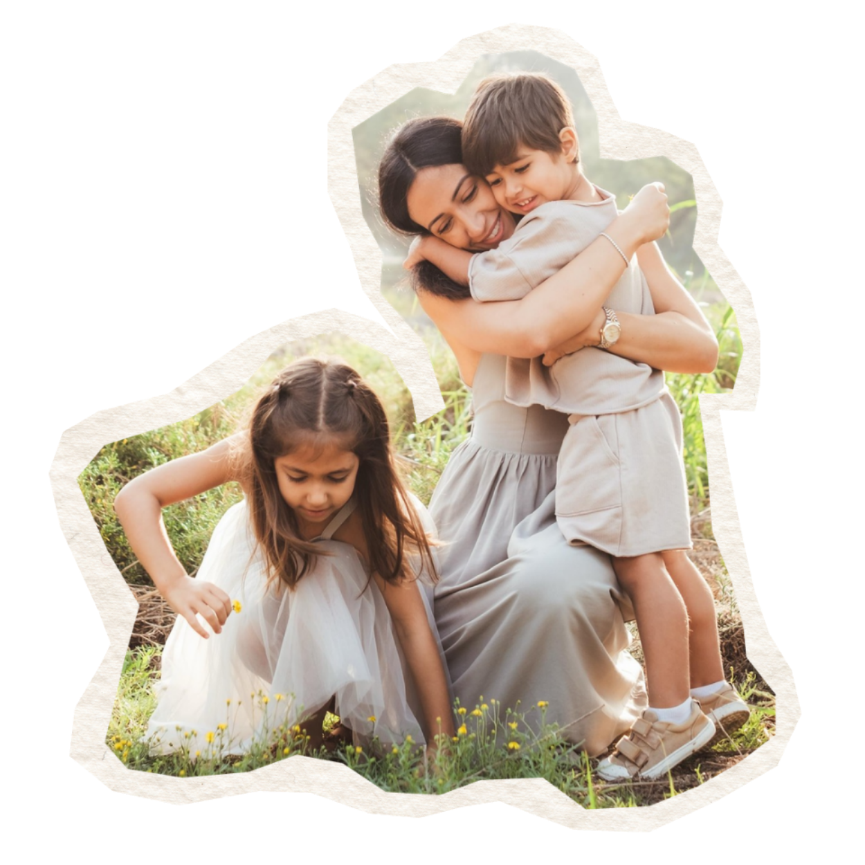 A woman with two children outdoors. The woman is hugging a boy, and a girl is crouching picking flowers in a grassy field.
