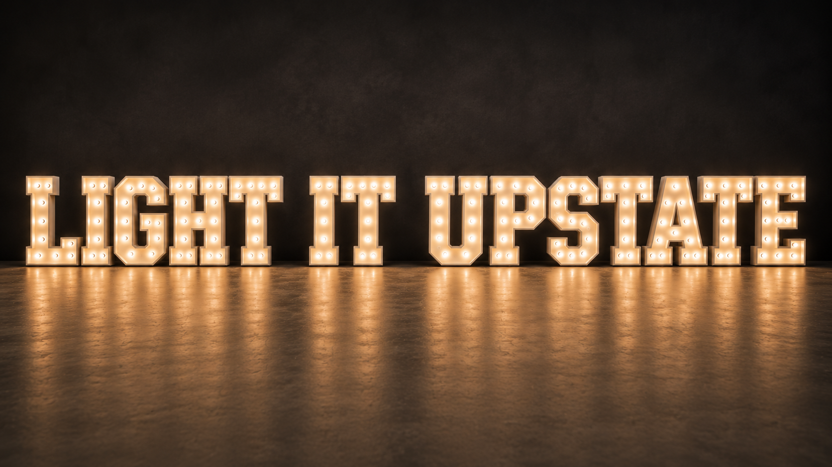 Illuminated marquee sign spelling out 'LIGHT IT UPSTATE' against a dark background, reflecting on the floor.