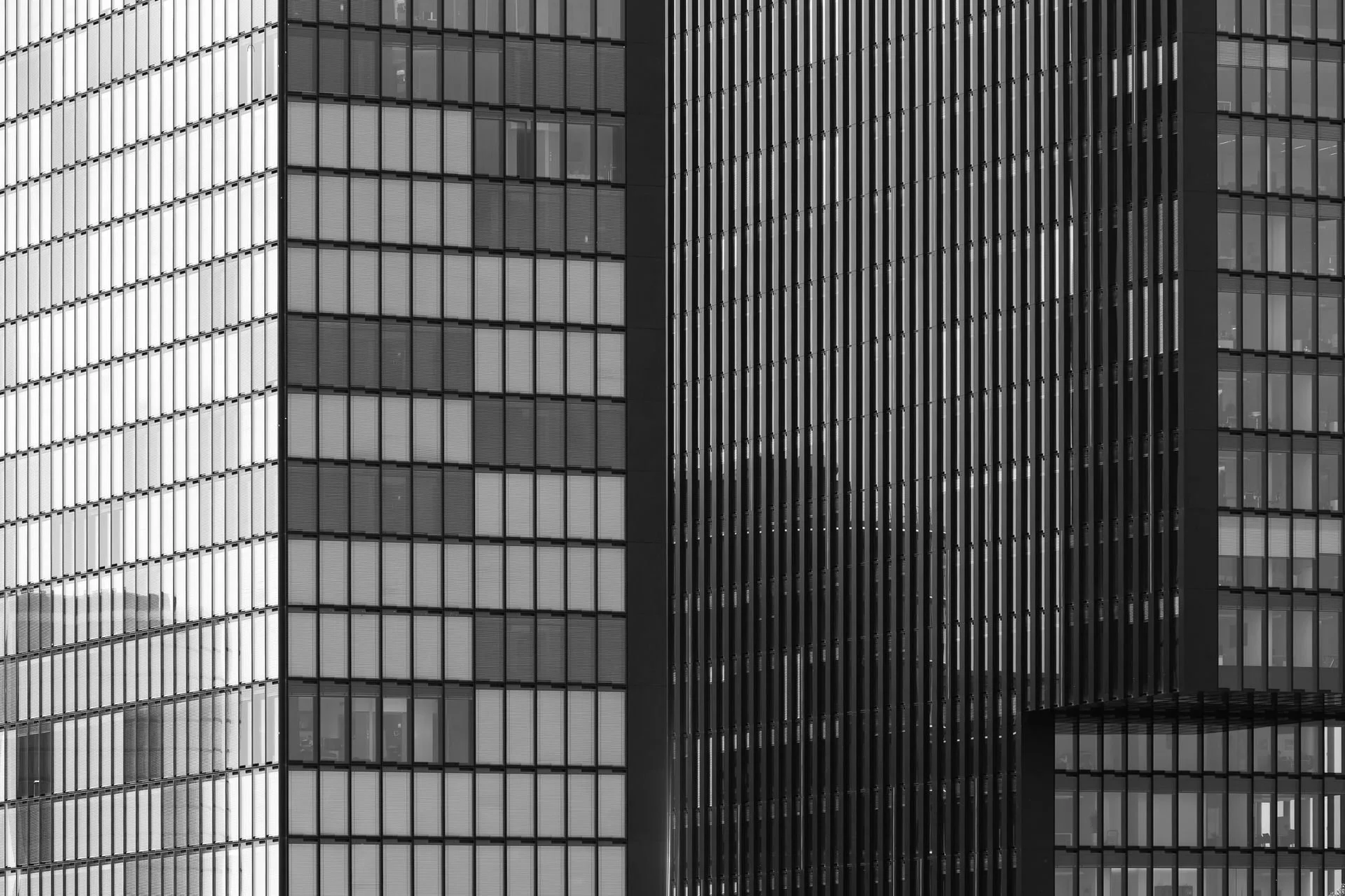 Close-up of a modern glass skyscraper with reflective windows and vertical metal slats.