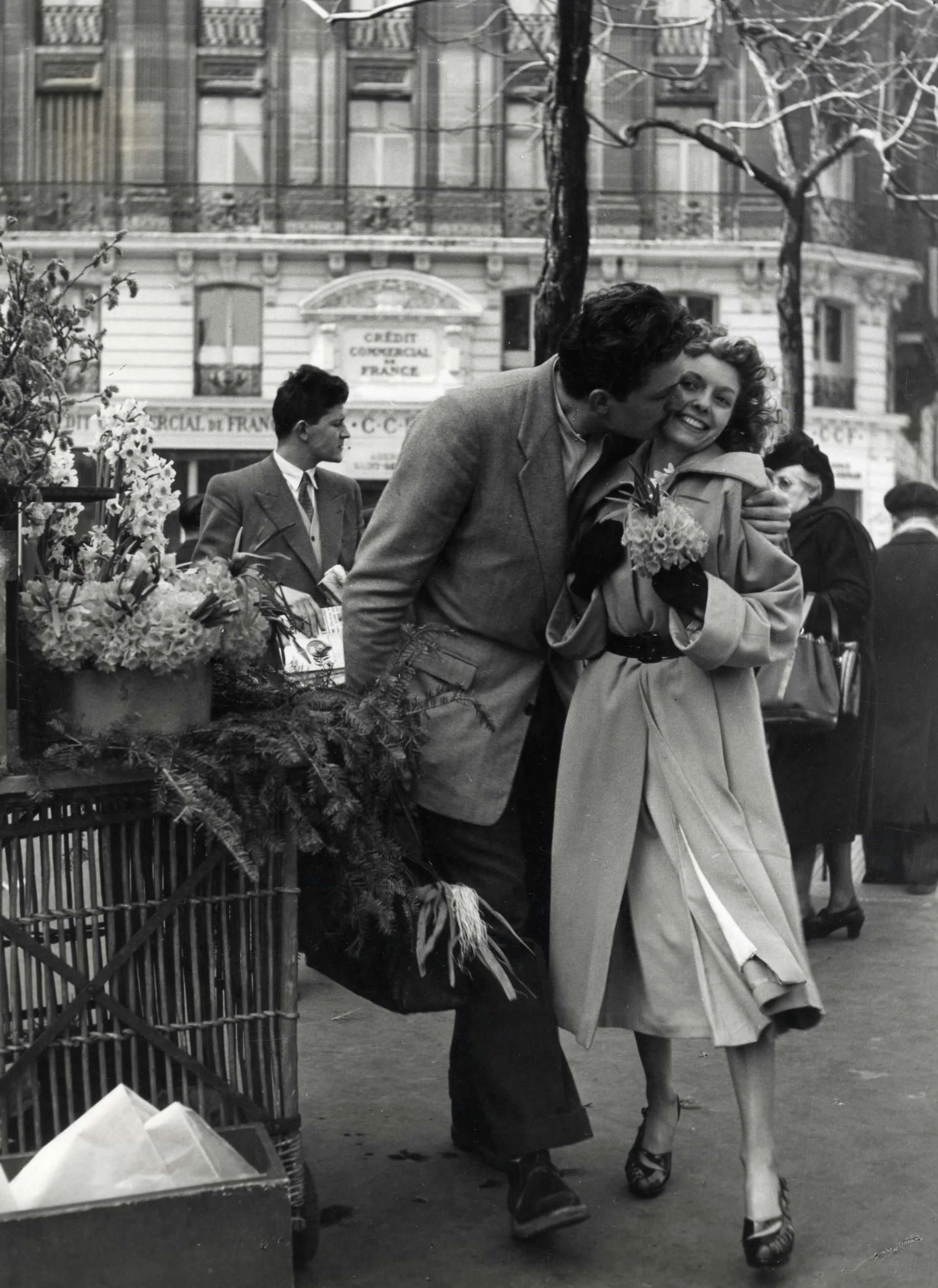 A joyful moment of affection unfolding in the middle of everyday Parisian life. Doisneau captures love with warmth and spontaneity, turning a simple kiss into a timeless celebration of human connection.