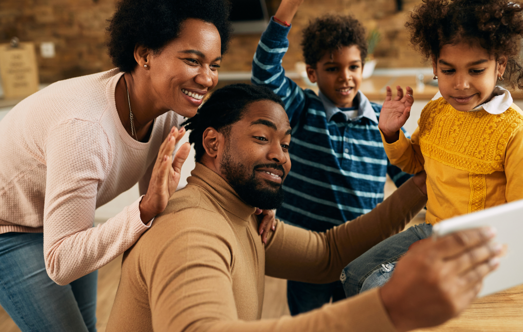 Family taking a selfie together, with two children and two adults smiling.
