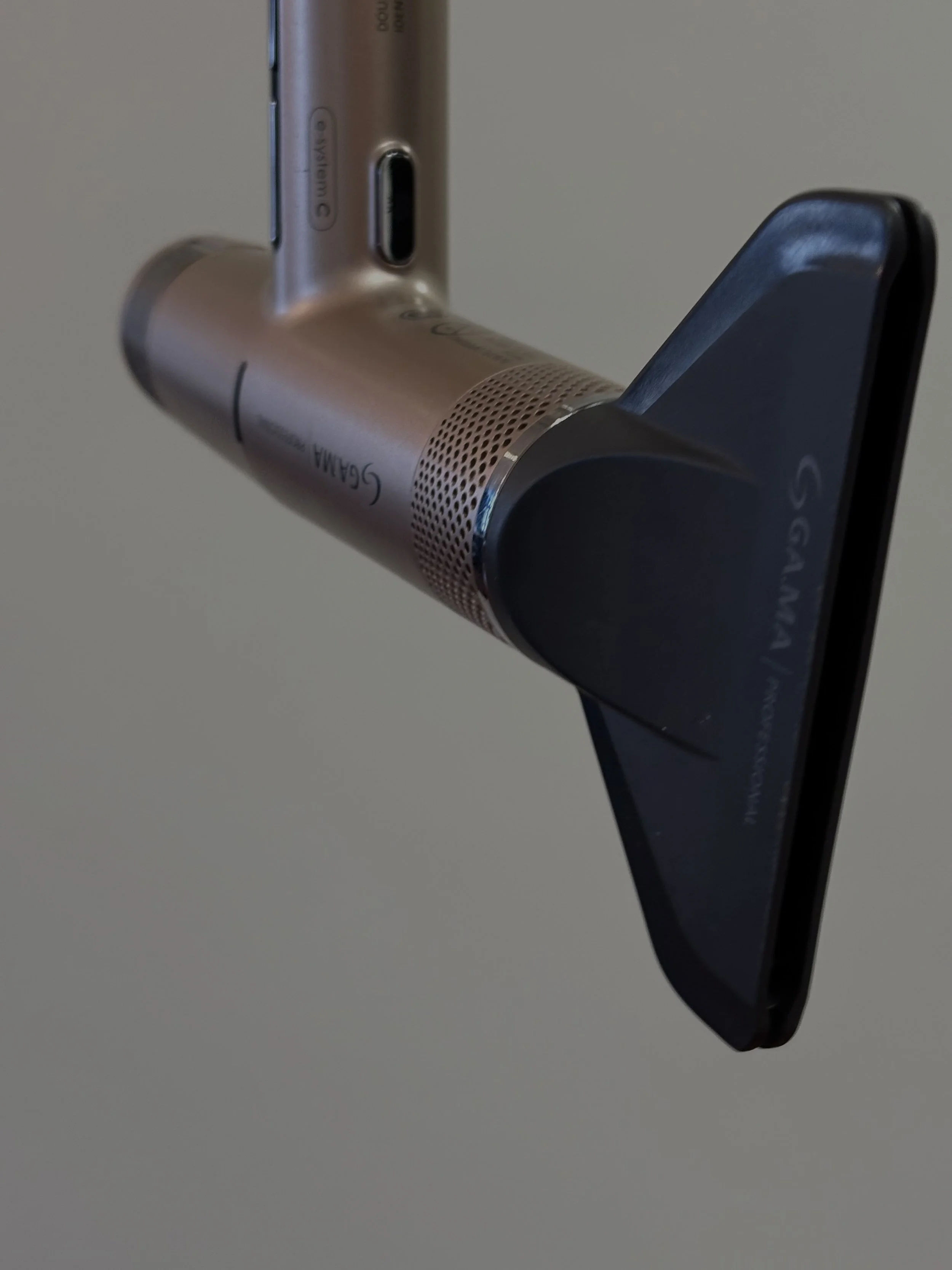 Close-up of a blow dryer leaning against a wall.