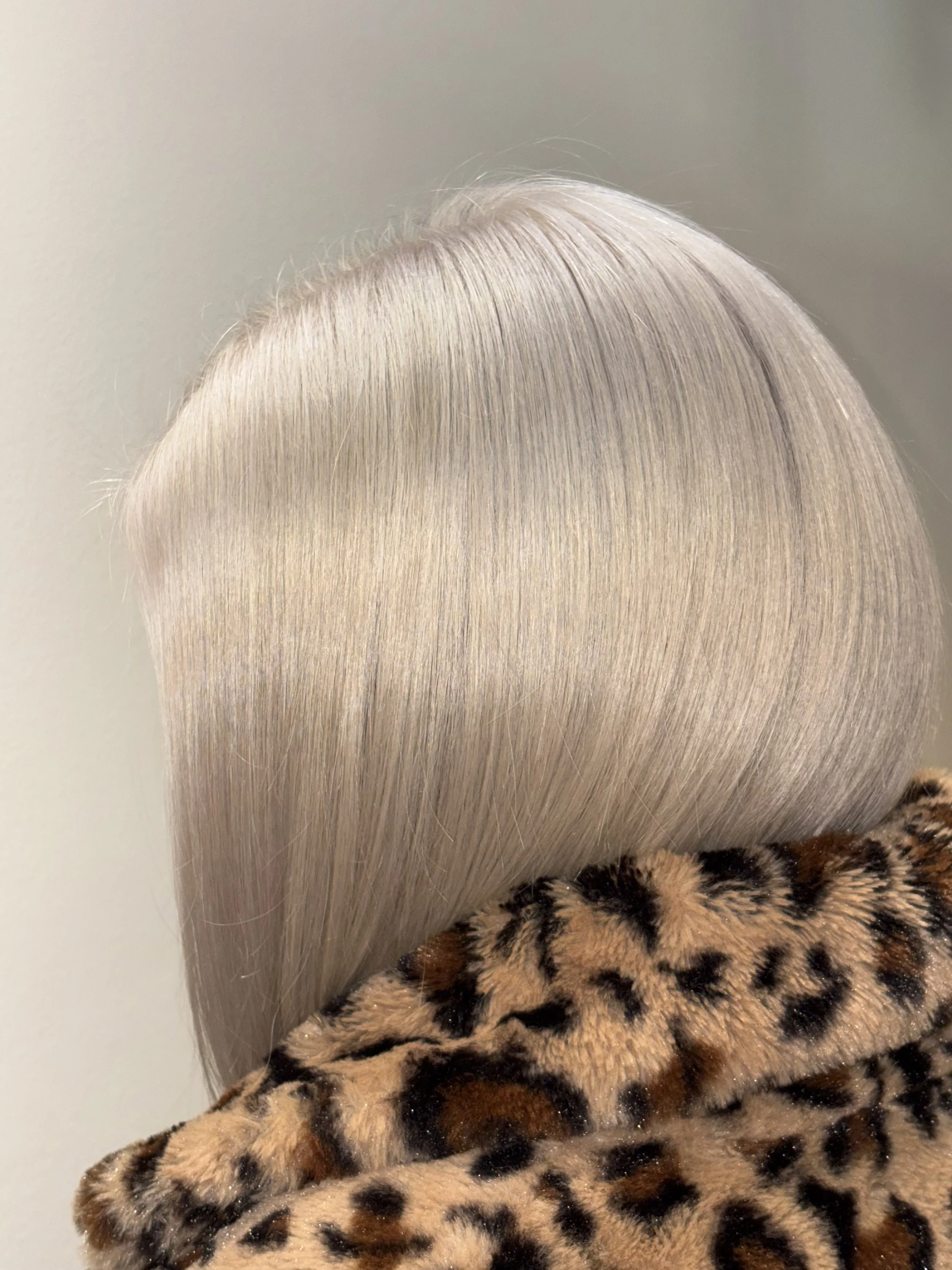 Close-up of platinum blonde hair and leopard print fabric.