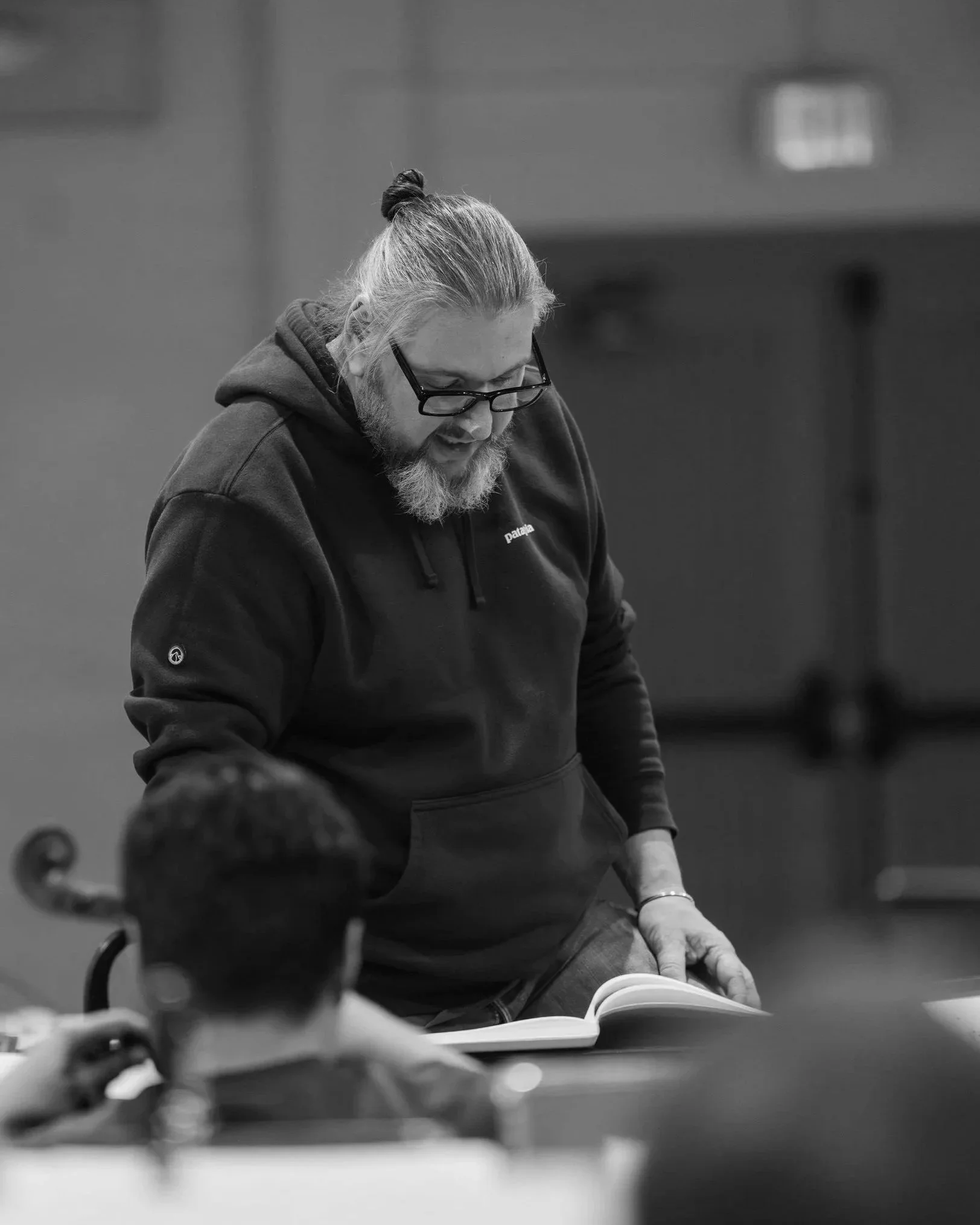 Daniel Henriks studying a musical score during an orchestra rehearsal.