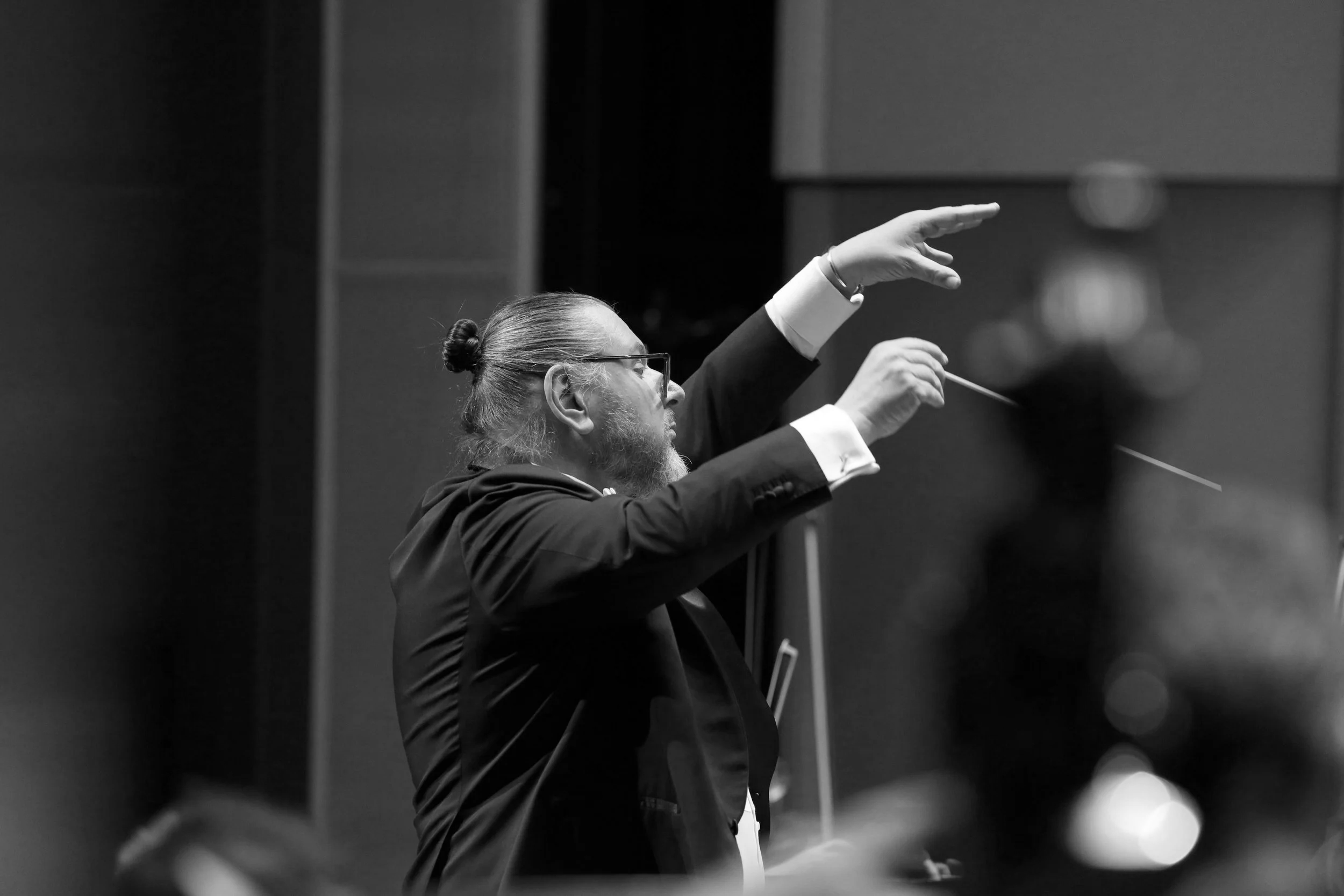 Conductor Daniel Henriks leading an orchestra in concert.