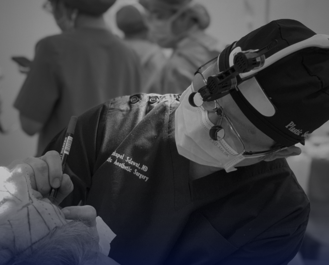 Dr. Rushapol Sdawat operating with surgical loupes at Intrarat Hospital, Bangkok