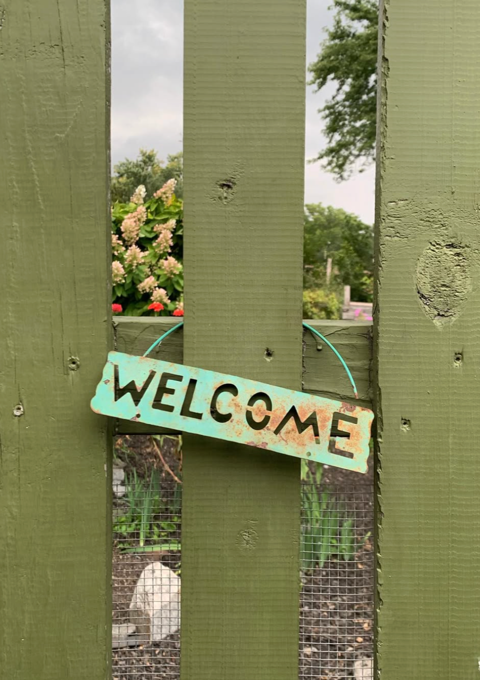 Decorative photograph taken by the author depicting a garden gate with a welcome sign