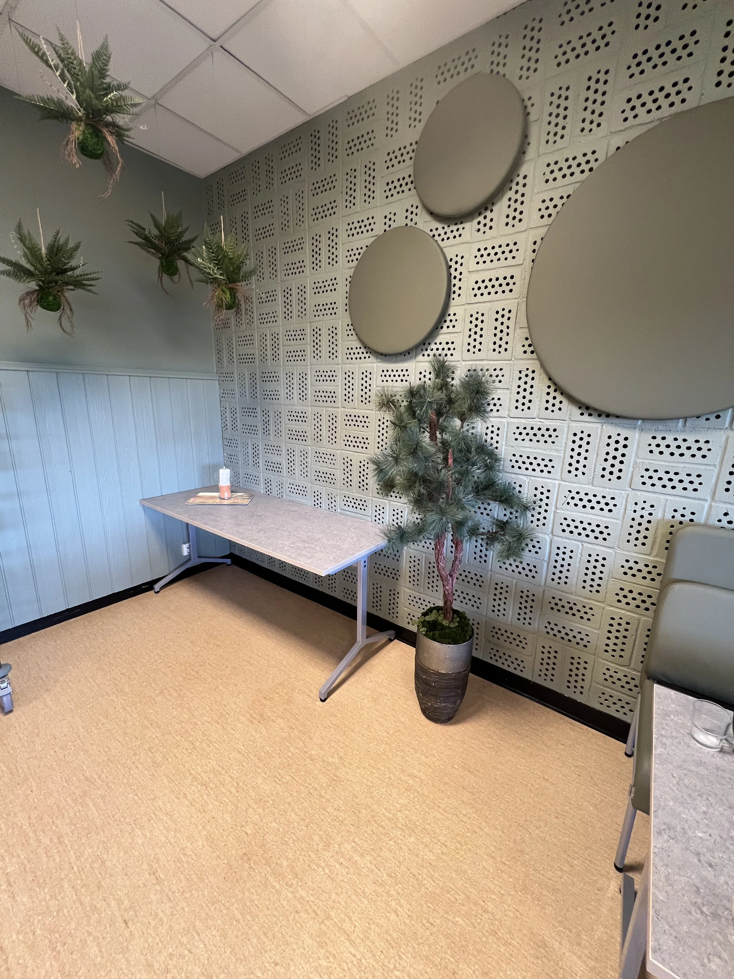 Skogsinspirerad miljö med gröna konstväxter och naturinslag i en del av skolmatsalen, skapad av Studio Mjölk