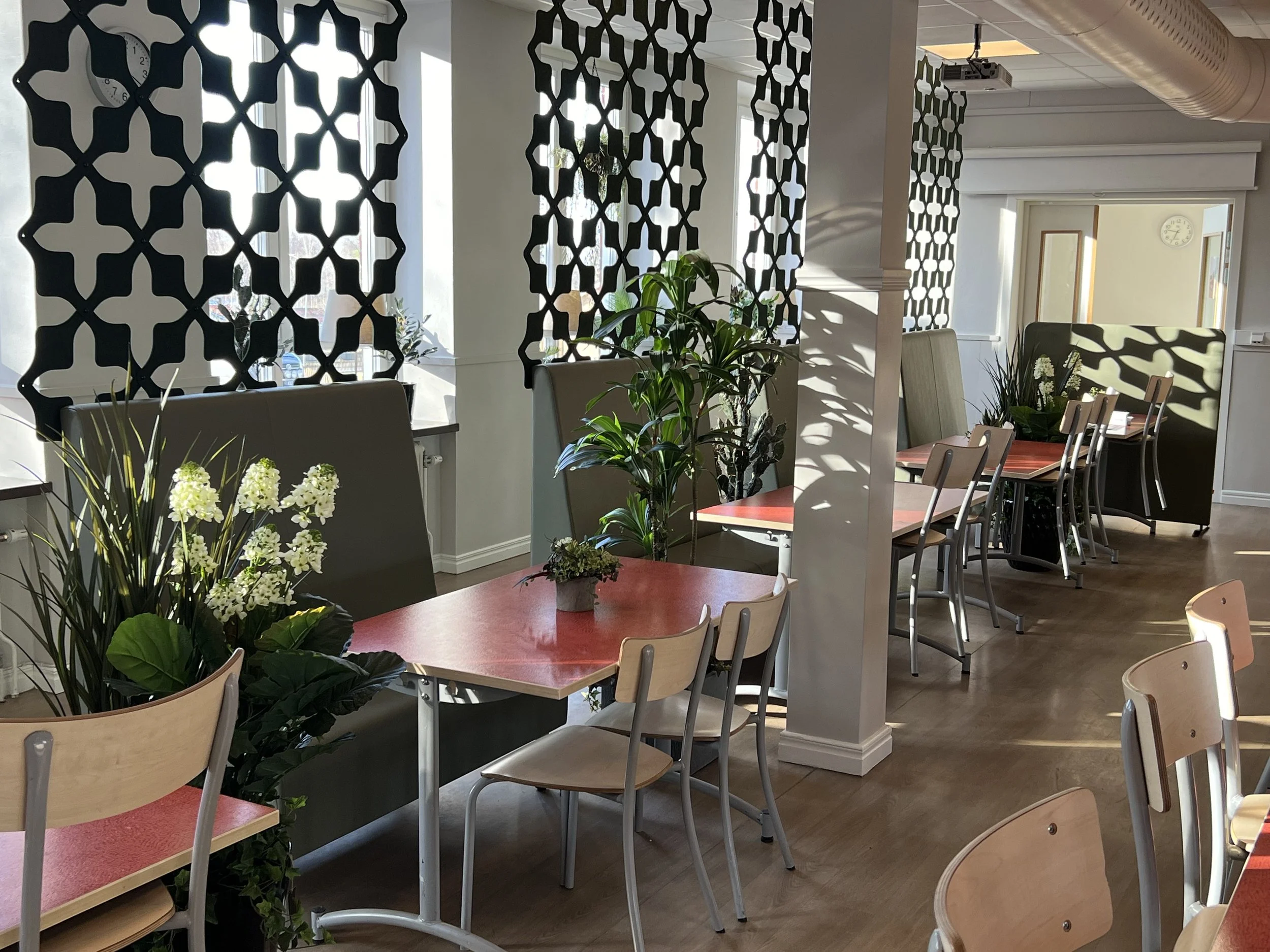 Interiörmiljö med konstväxter och dekorativa arrangemang skapad av Studio Mjölk.
