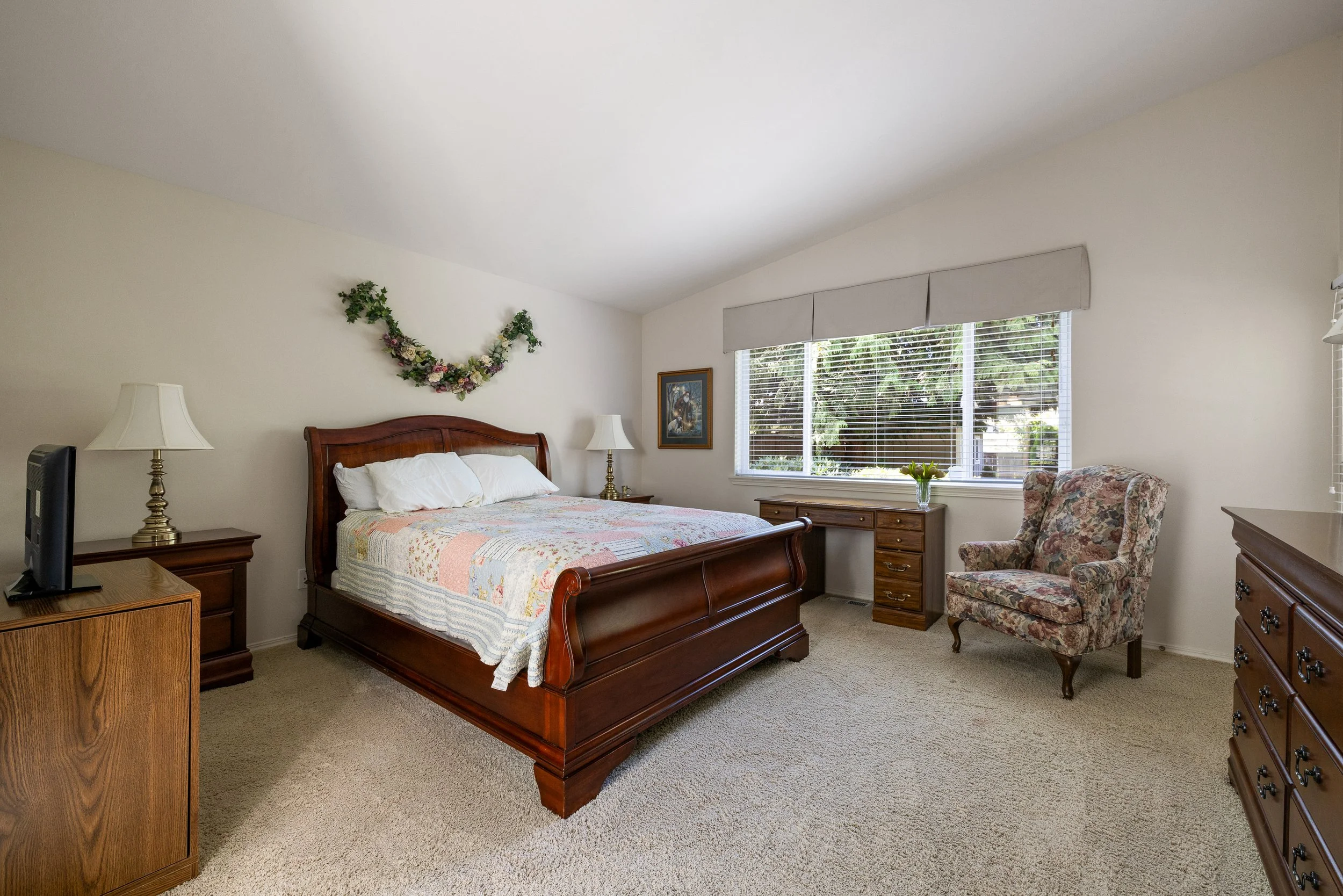 This primary bedroom offers a large picture window overlooking the beautiful backyard.