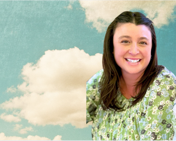 Kendra- Root Real Estate Broker  smiling in front of a partly cloudy sky background.