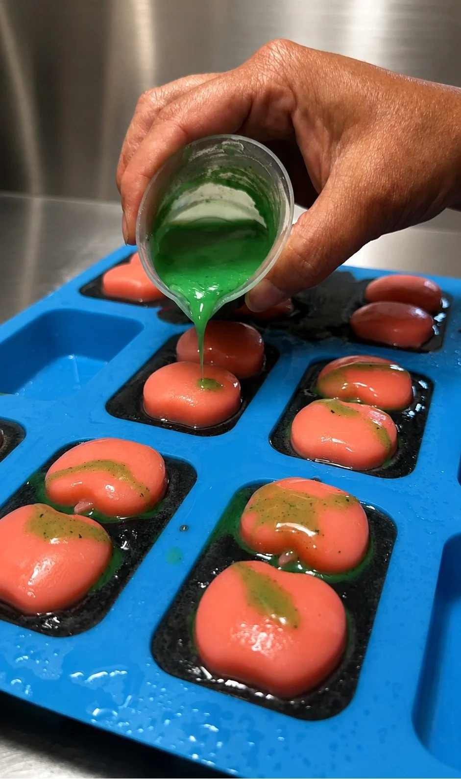 Behind the scenes at Bubbles & Charm Soaps, hand-pouring the finishing “poison” detail onto Poison Apple soaps.