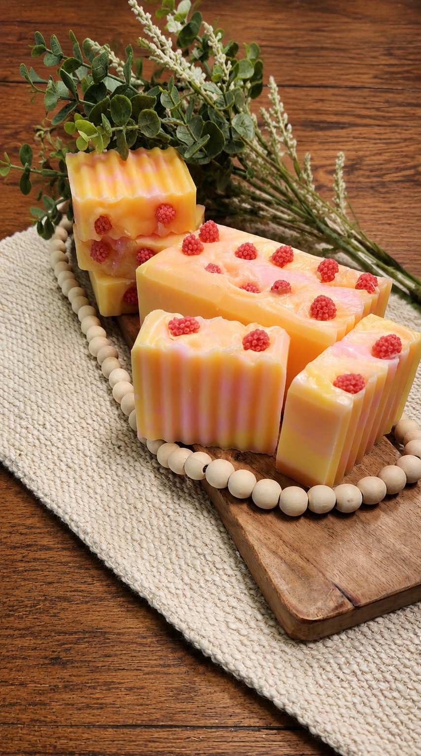 Pink Lemonade is a handcrafted shea butter soap featuring raspberry-inspired embeds and the bright, refreshing scent of sweet raspberry and zesty lemon.