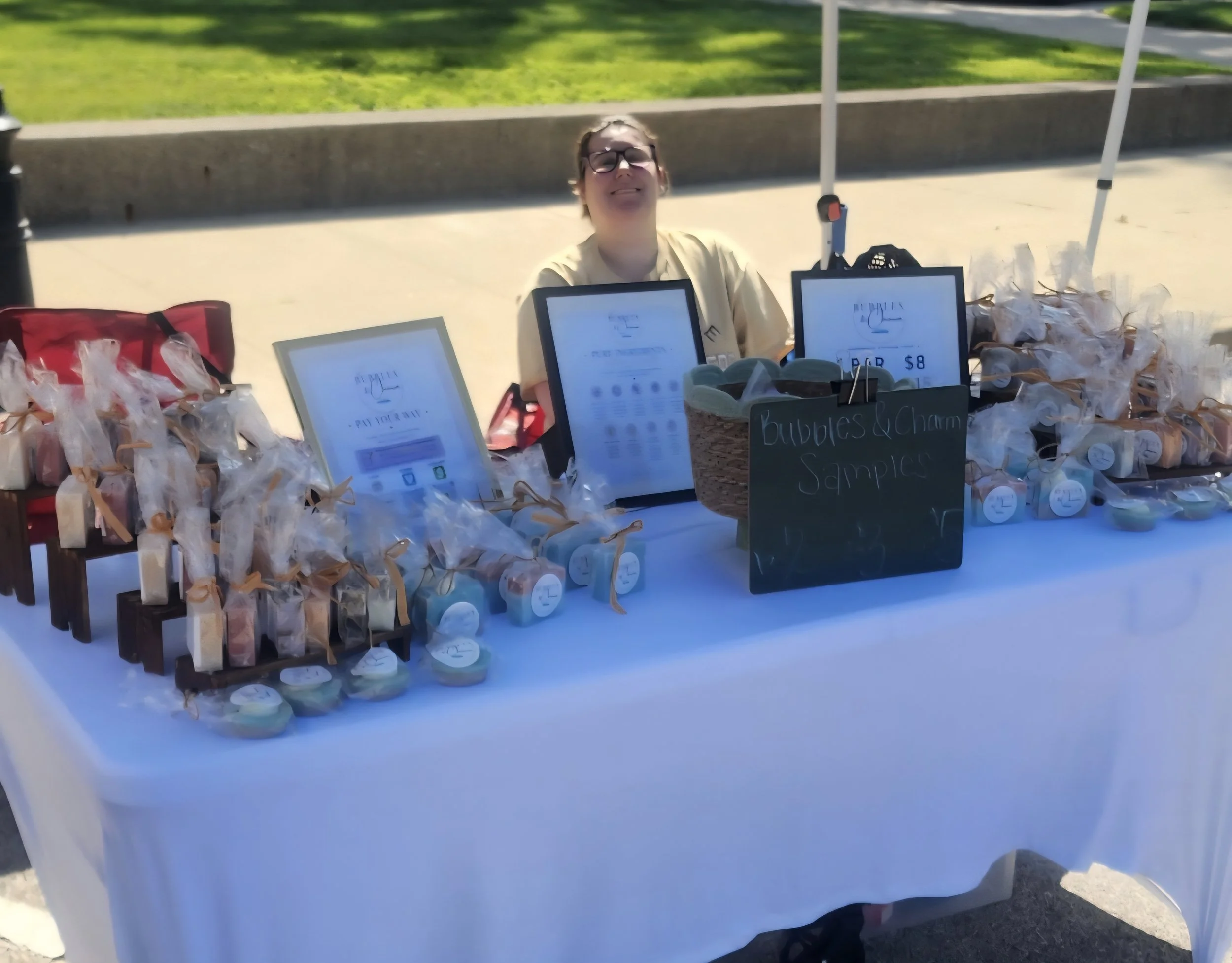 Handcrafted soaps displayed at the Bubbles & Charm Soaps booth during a local artisan market.