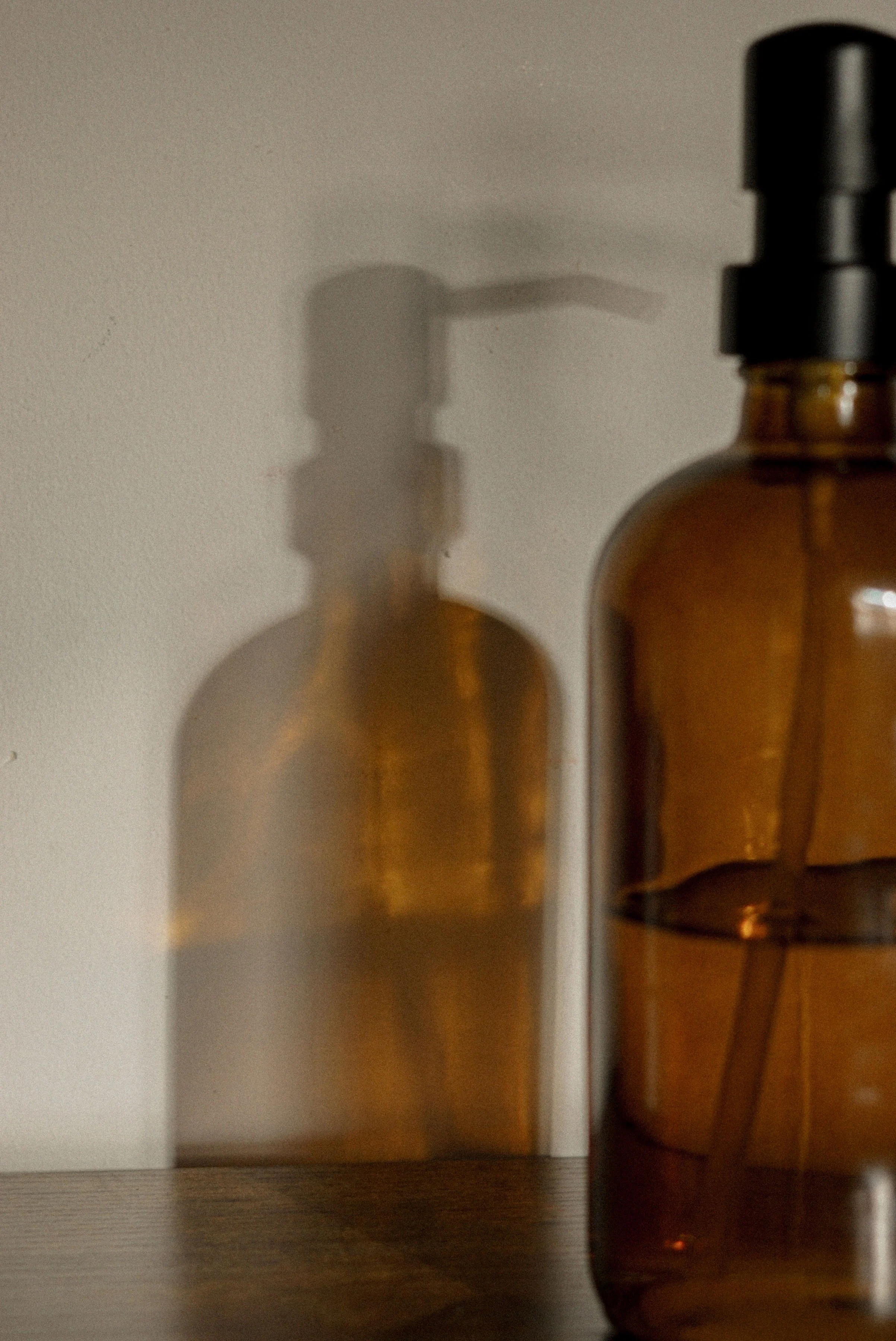 Polish - Amber glass bottles with pump dispenser on neutral surface - TVS.jpg