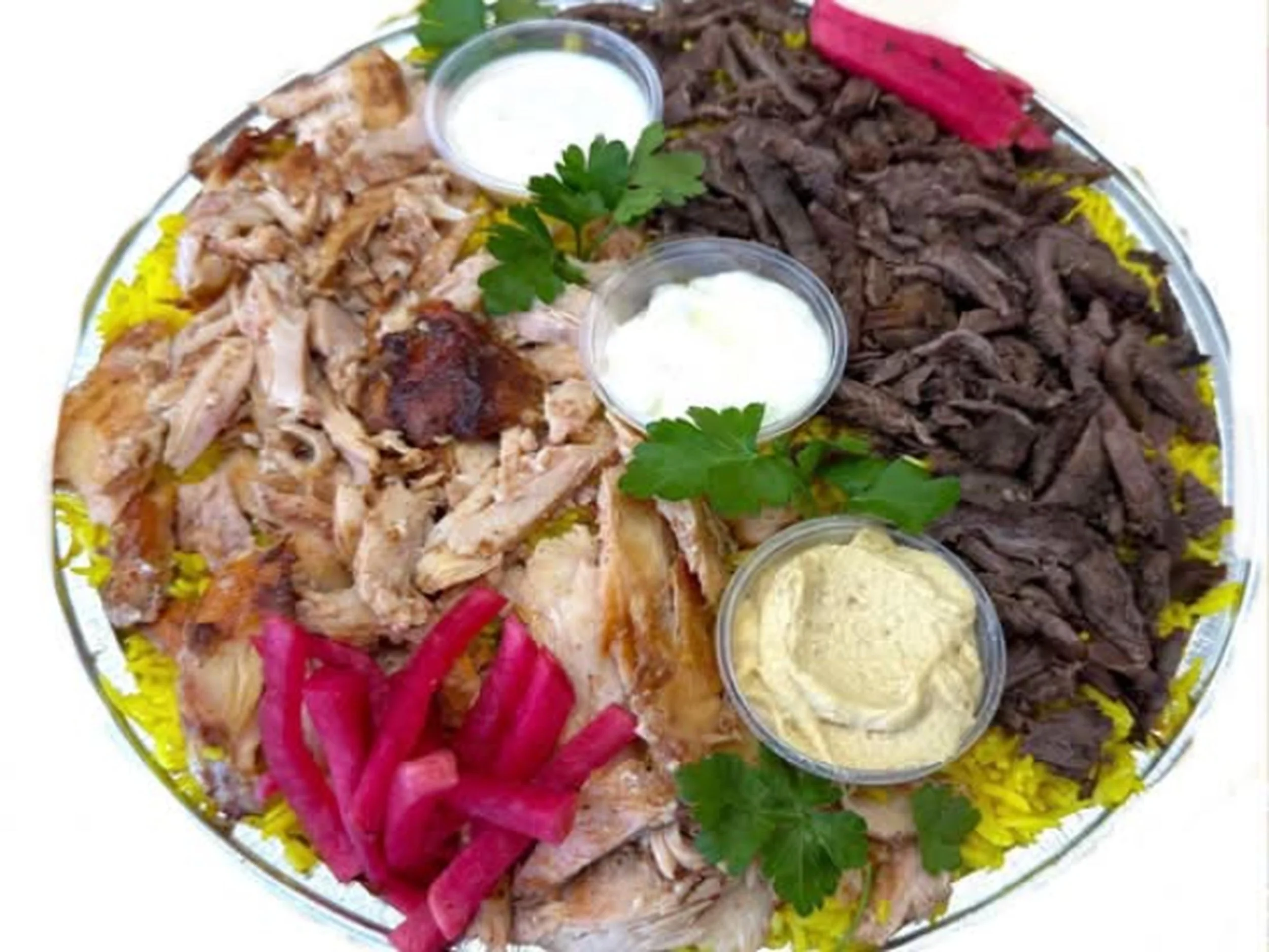 Plate of shredded cooked chicken, sliced beef, pink pickled vegetables, yellow rice, and small containers of sauce and sour cream garnished with parsley.