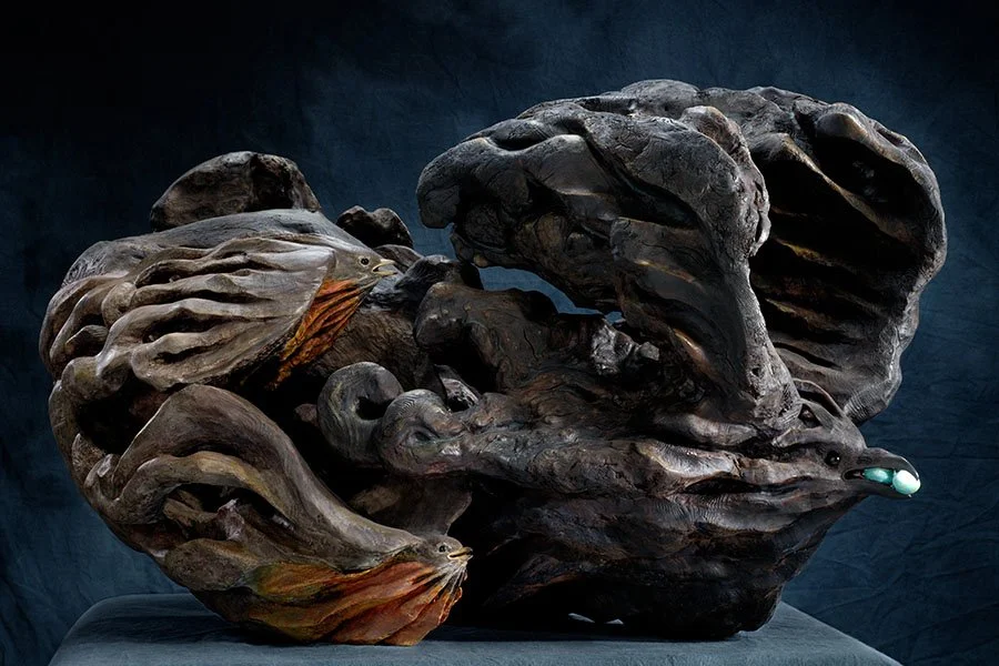 A detailed sculpture of a dragon's head, made from dark wood and featuring glowing eyes.