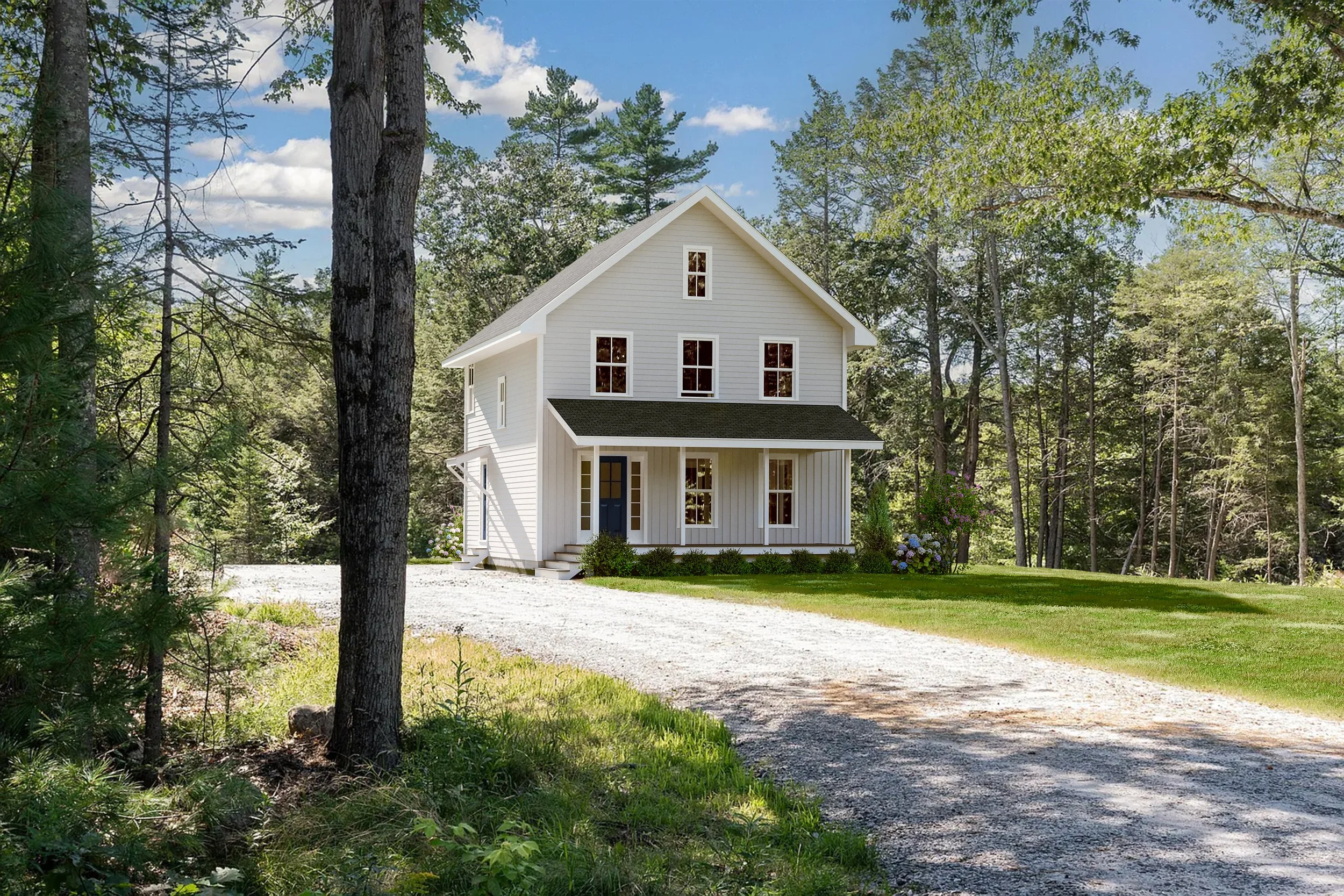 A white two-story house with a black front door, surrounded by tall trees and greenery, with a gravel driveway in front and blue sky with clouds overhead.
