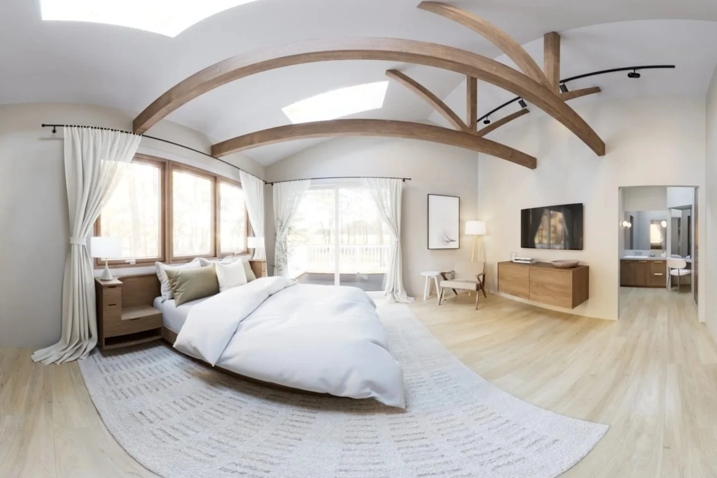 Bright bedroom with large bed, wooden nightstands, white bedding, multiple windows with curtains, wooden ceiling beams, TV on wooden console, sitting area with chair and lamp, and an adjacent bathroom with vanity and mirror.