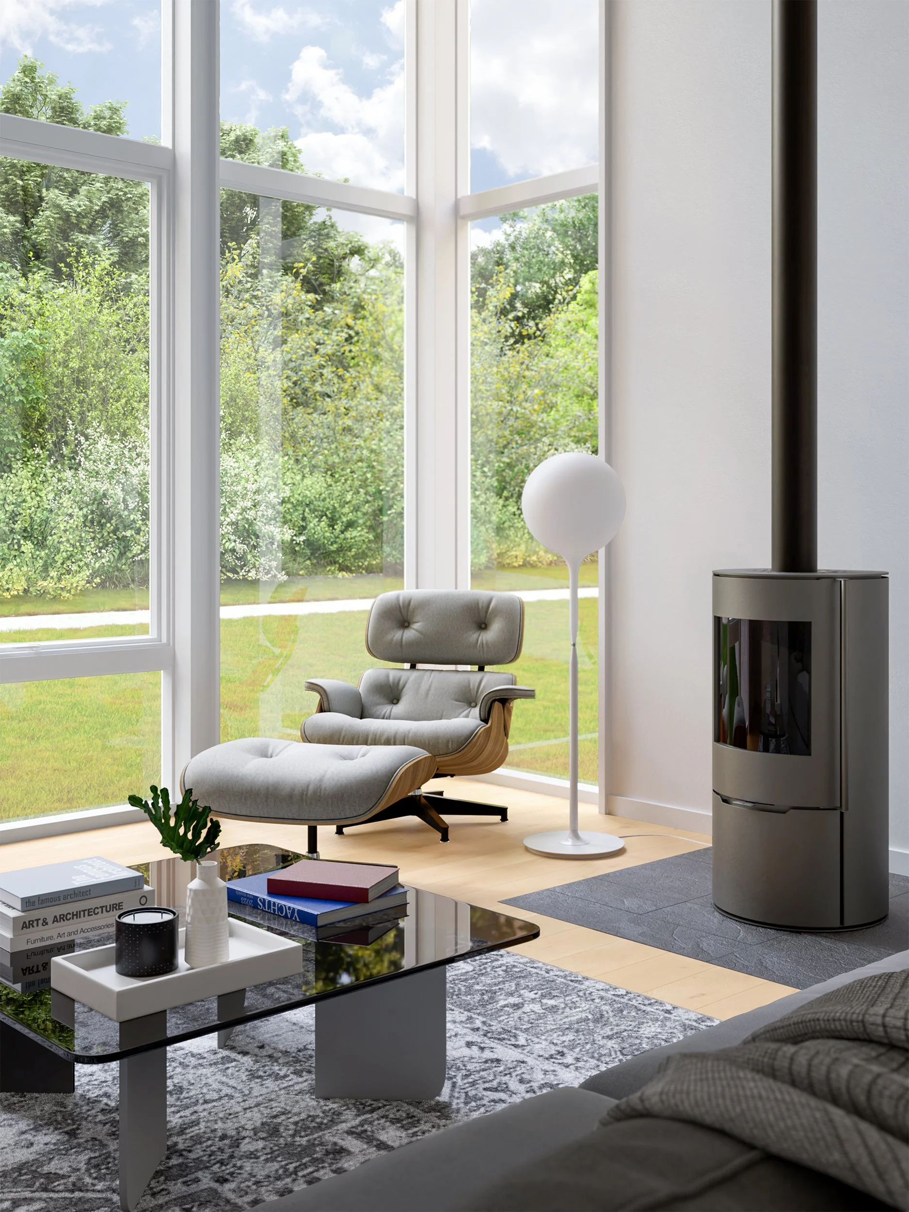 A modern living room with large windows showing green trees and a blue sky outside. There is a white lounge chair with a matching ottoman, a white standing lamp, a coffee table with books and decorative items, and a gray and white patterned rug. A wo