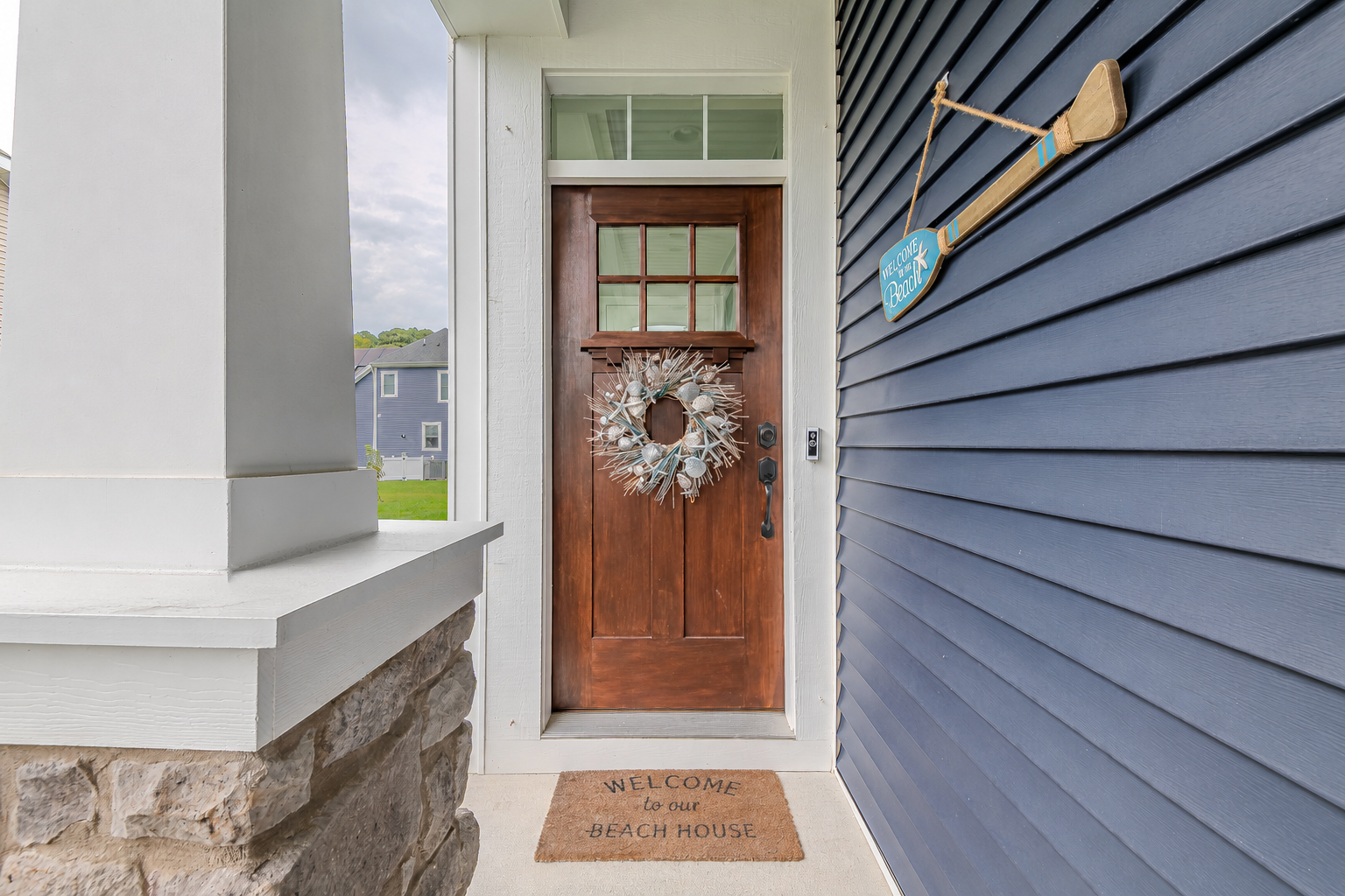 Coastal Delaware beach house entrance with a natural wood door and welcome mat