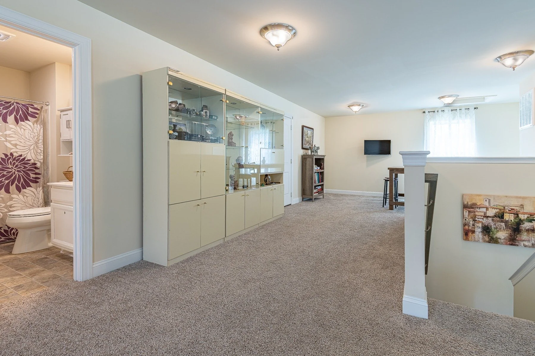 Upstairs loft with display cabinetry and nearby full bathroom at 28839 W Henry Place.