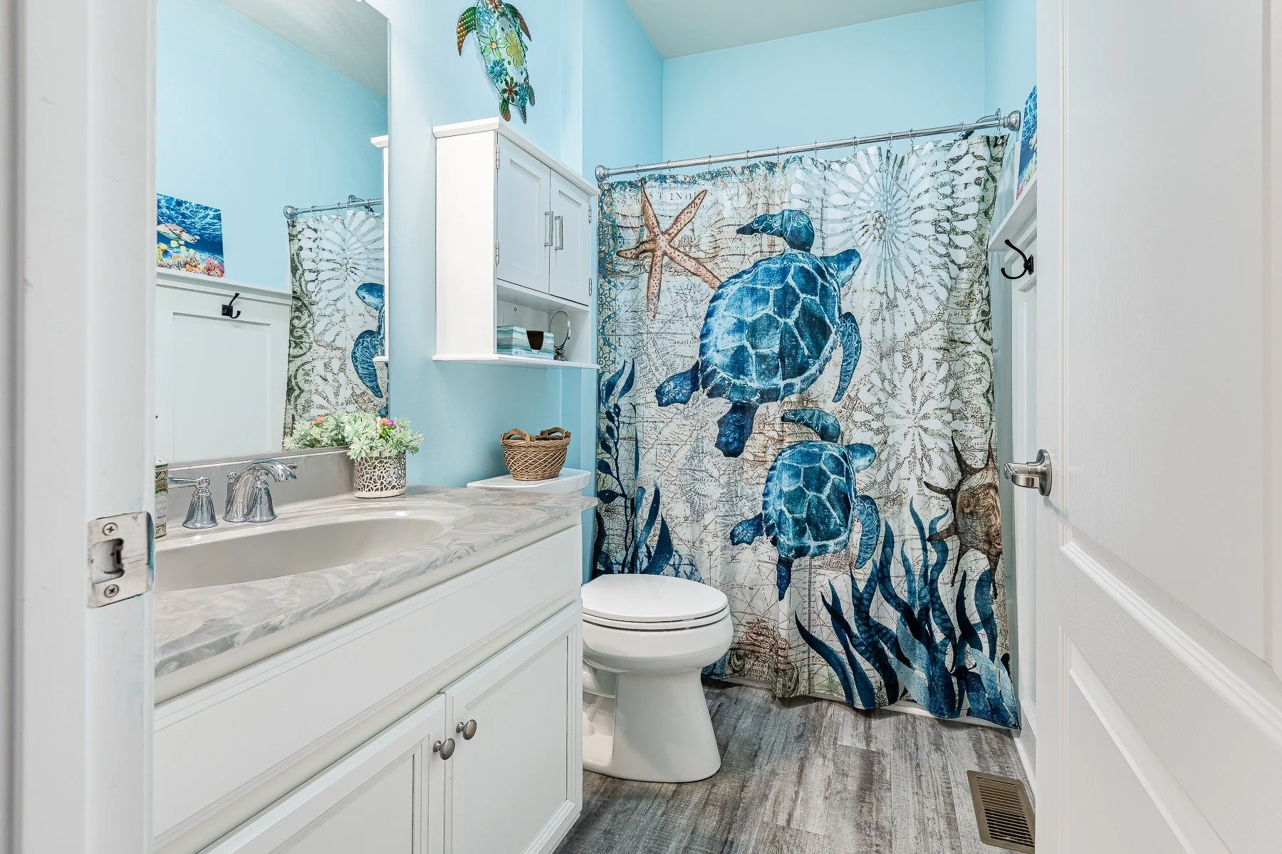 Full bathroom with white vanity and sea-turtle shower curtain at 28839 W Henry Place.