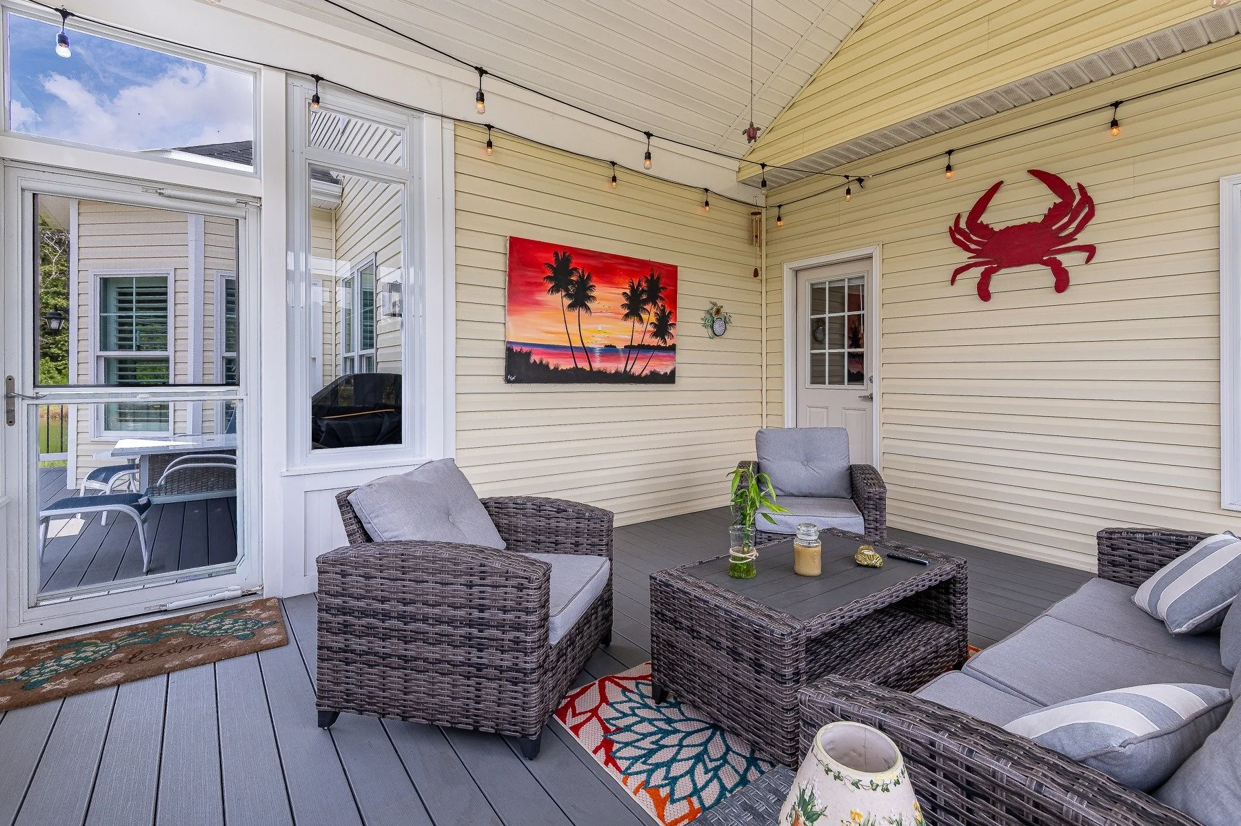 Screened porch seating area with coastal decor at 28839 W Henry Place.