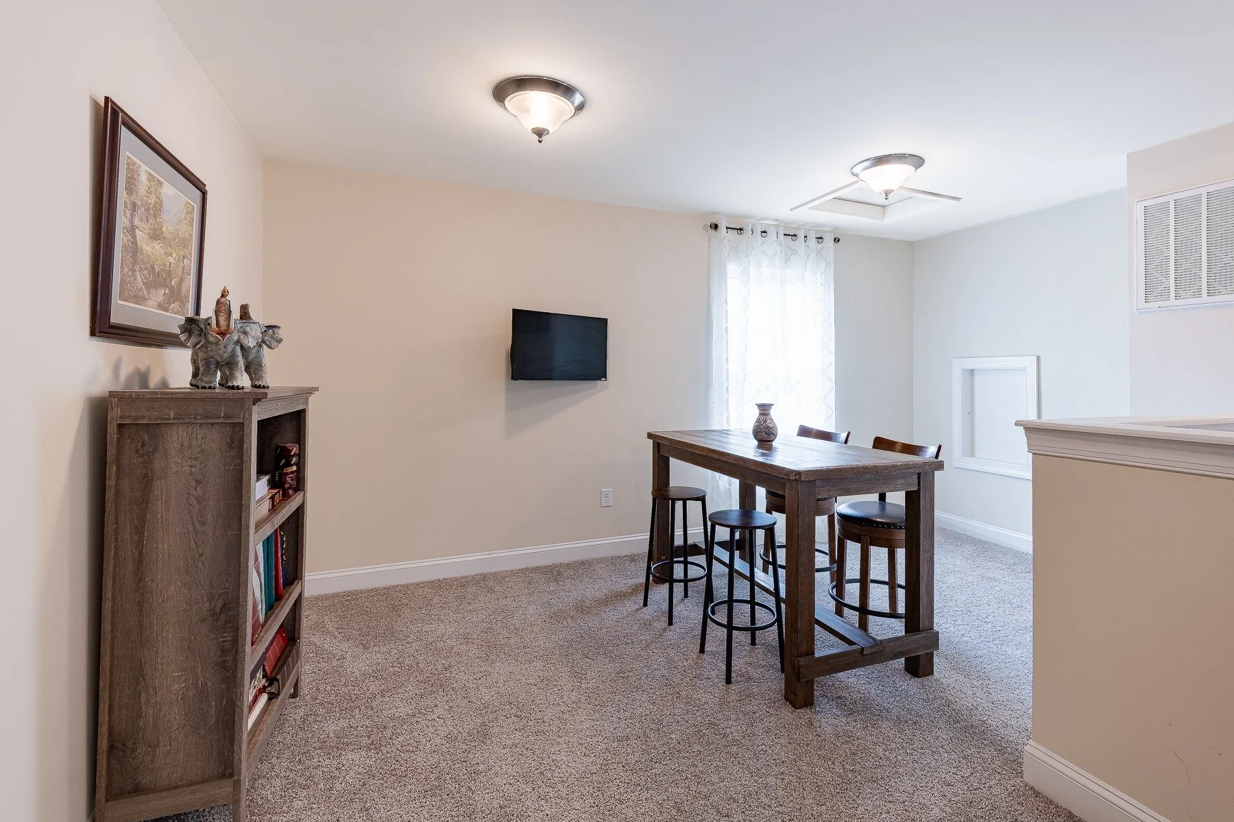 Loft sitting area with high-top table and wall-mounted television at 28839 W Henry Place.