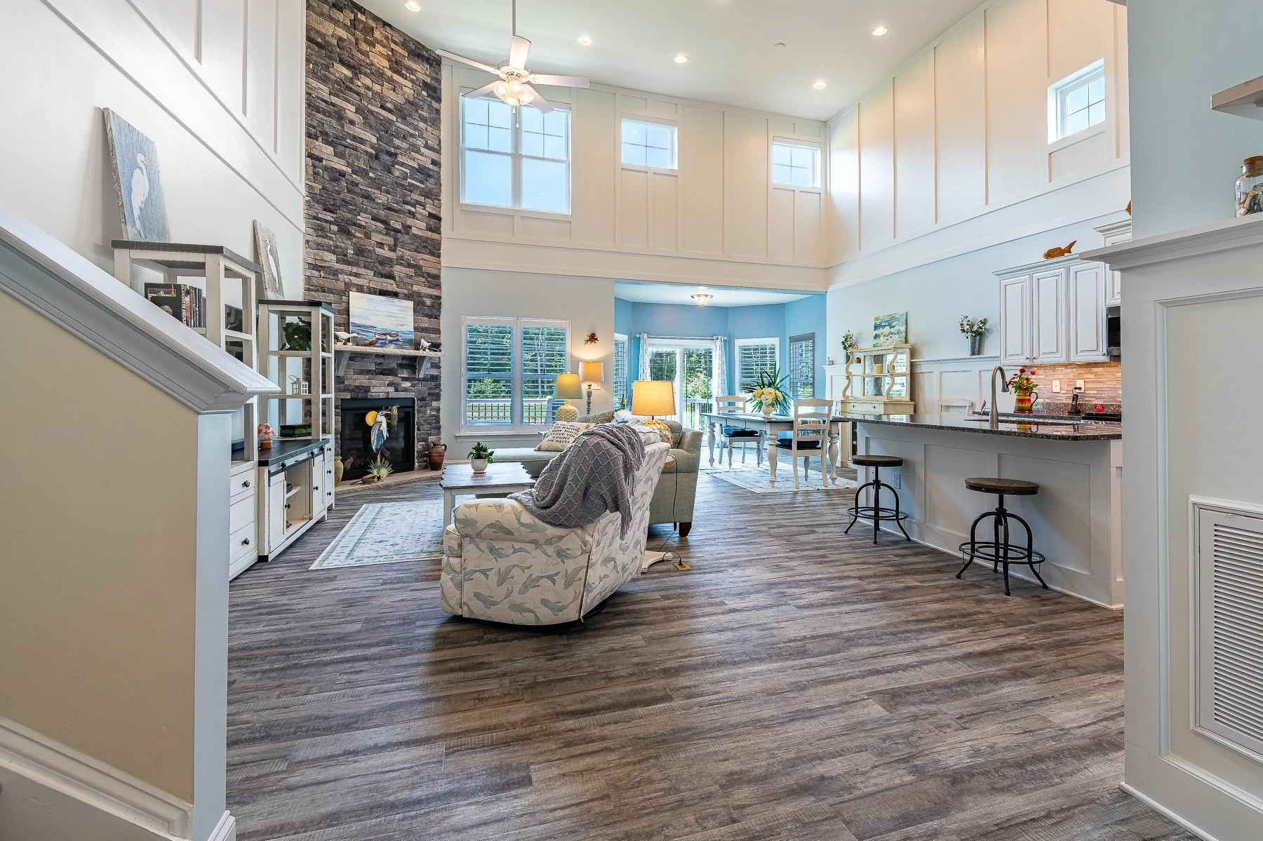 Open-concept great room with two-story stone fireplace, kitchen, and dining area at 28839 W Henry Place.