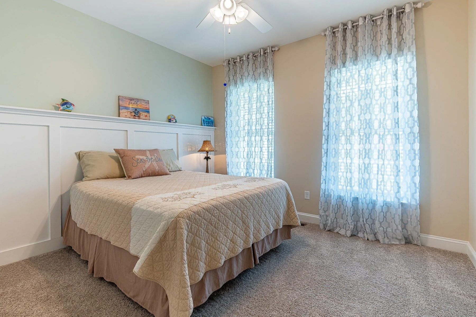 Guest bedroom with tall windows and coastal-inspired decor at 28839 W Henry Place.