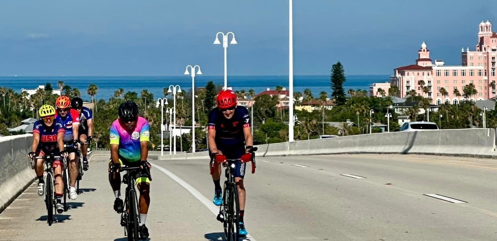 Group of five club cyclists riding on a road near the coast with sunny weather near the 5 star  don cesar hotel at St Pete Beach. They are on a Sunday club run and with the ocean visible in the background