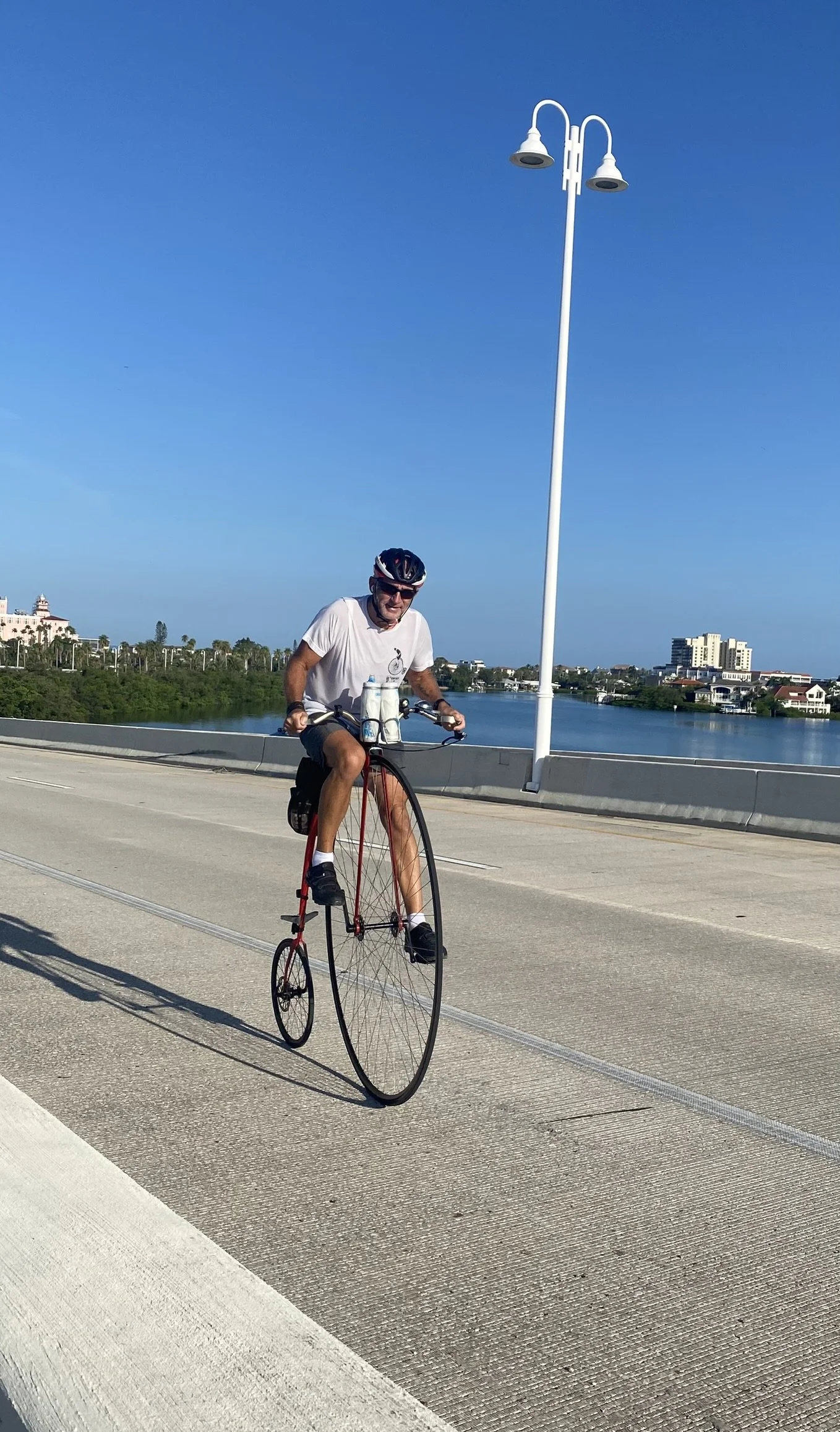 Cyclist enjoying a cycling trip on his unusual and modern take on a vintage penny farthing cycle