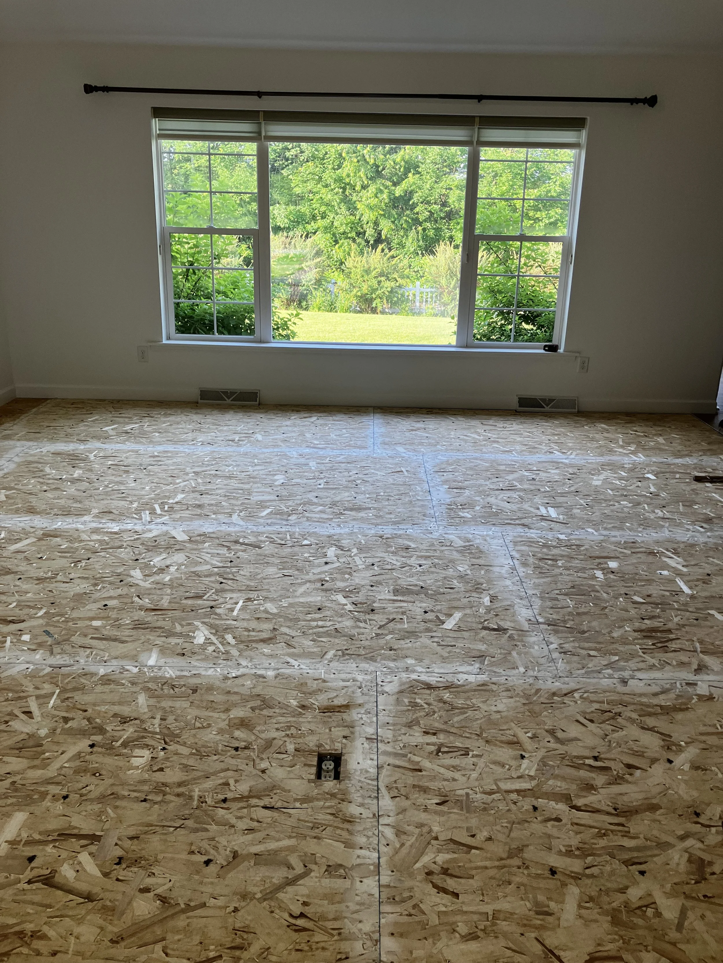 Living room prepped with plywood flooring, before LVP installation