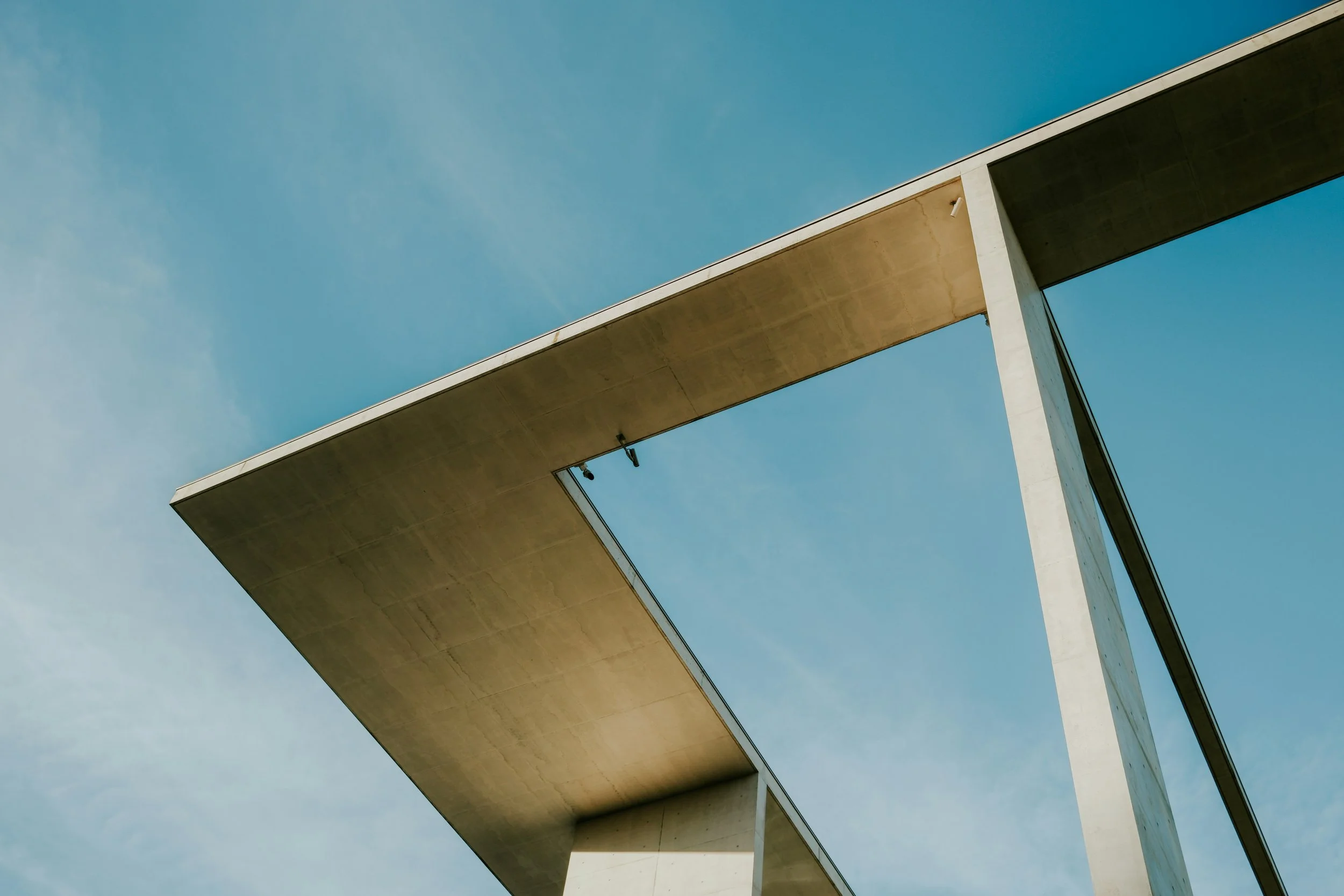 The frame of an architectural structure  against a blue sky.