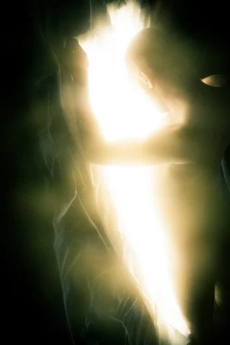 Silhouette of a couple embracing with bright light behind them