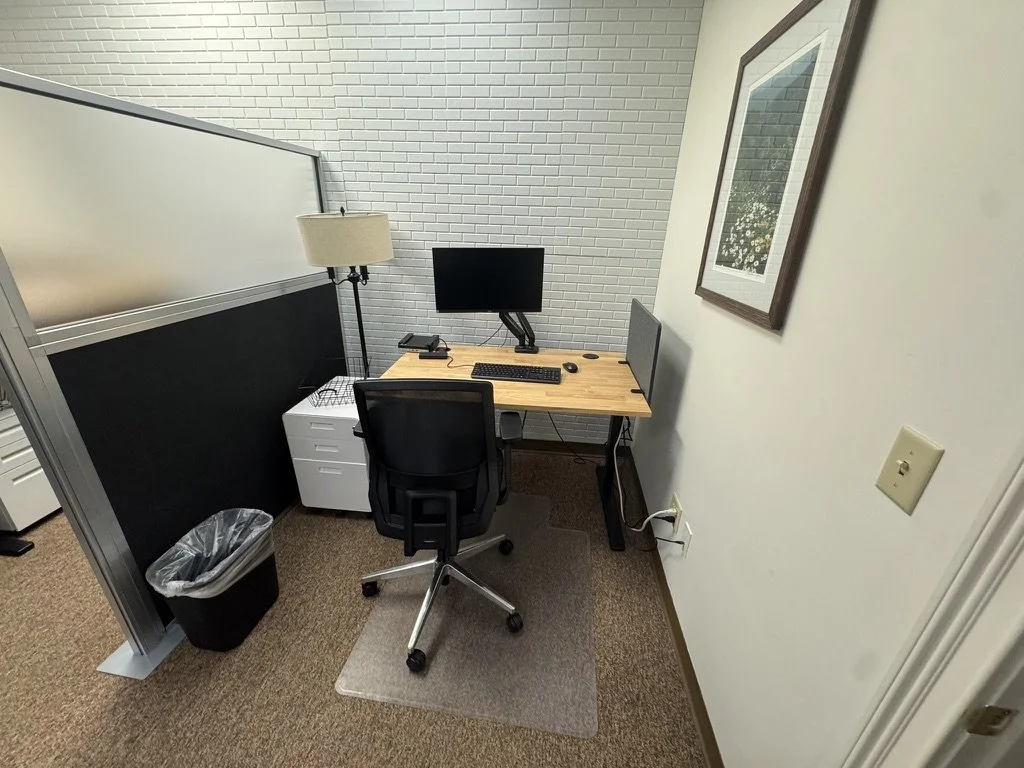 A dedicated desk at Goodwork with a monitor, task chair, and a locking cabinet underneath.