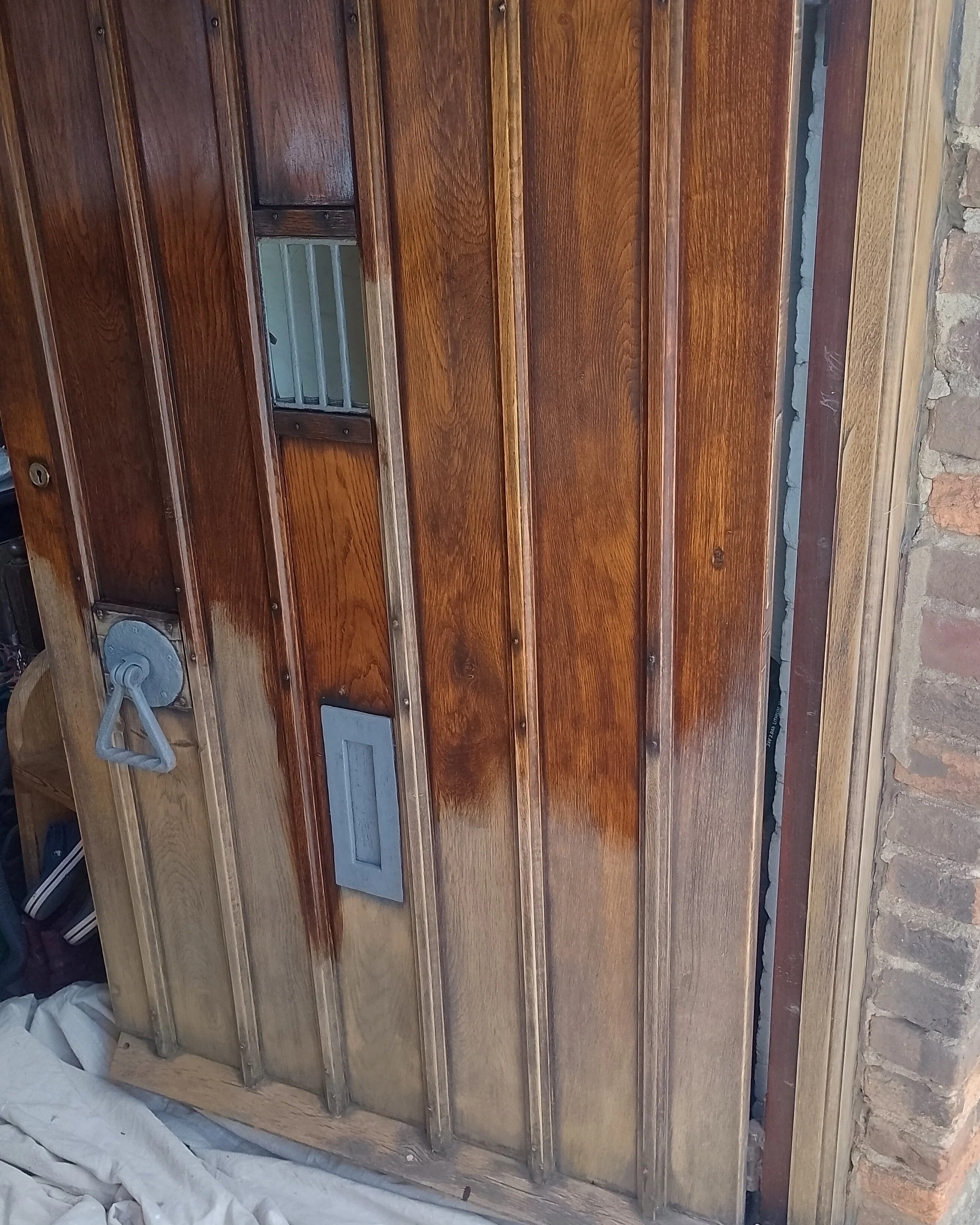 Wood-paneled staircase with metal railings and brick wall on the right side, some construction materials and white fabric at the bottom.