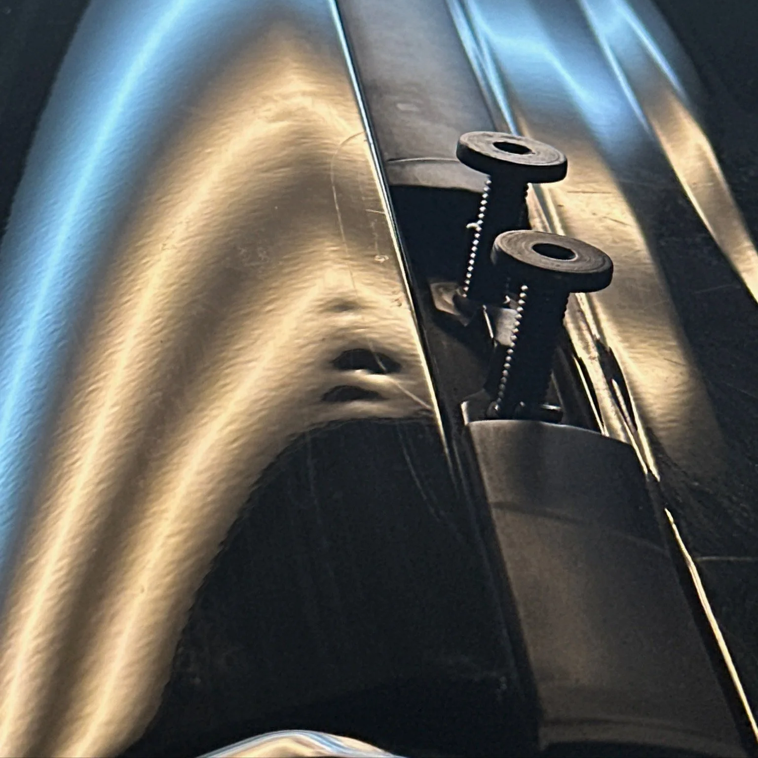 Close-up of a truck bed with dings and dents being illuminated by pdr lighting for inspection before using painteless dent repair techniques to recover vehicles body.