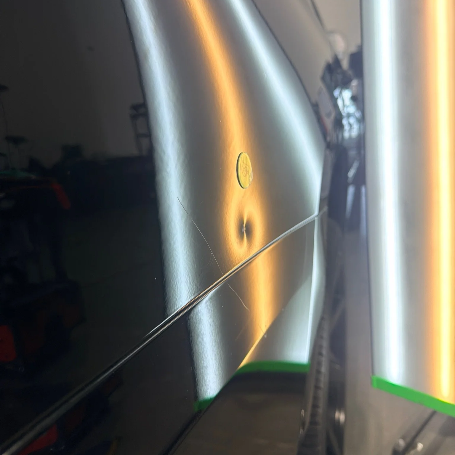 Deep fender dent illuminated with a PDR light during paintless dent repair evaluation