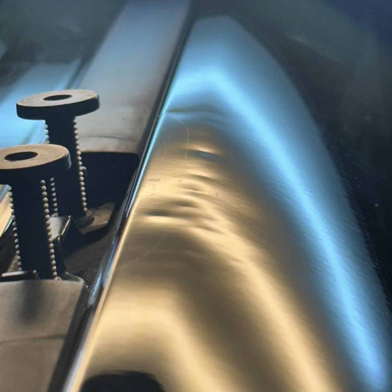 Small dent visible under reflection lighting before professional paintless dent removal