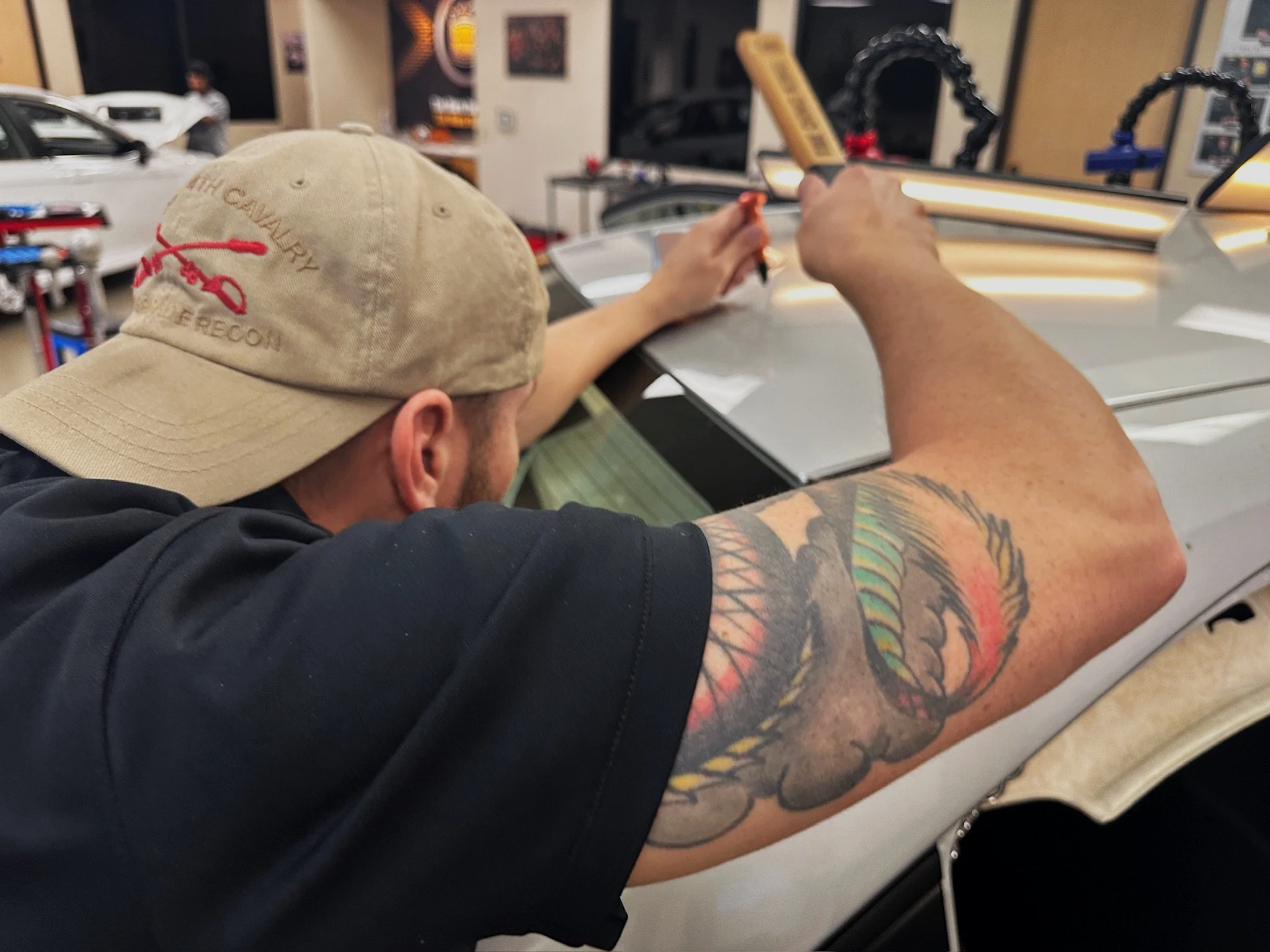 Arvada Dent Repair technician repairing hail damage on top of sedan vehicle.