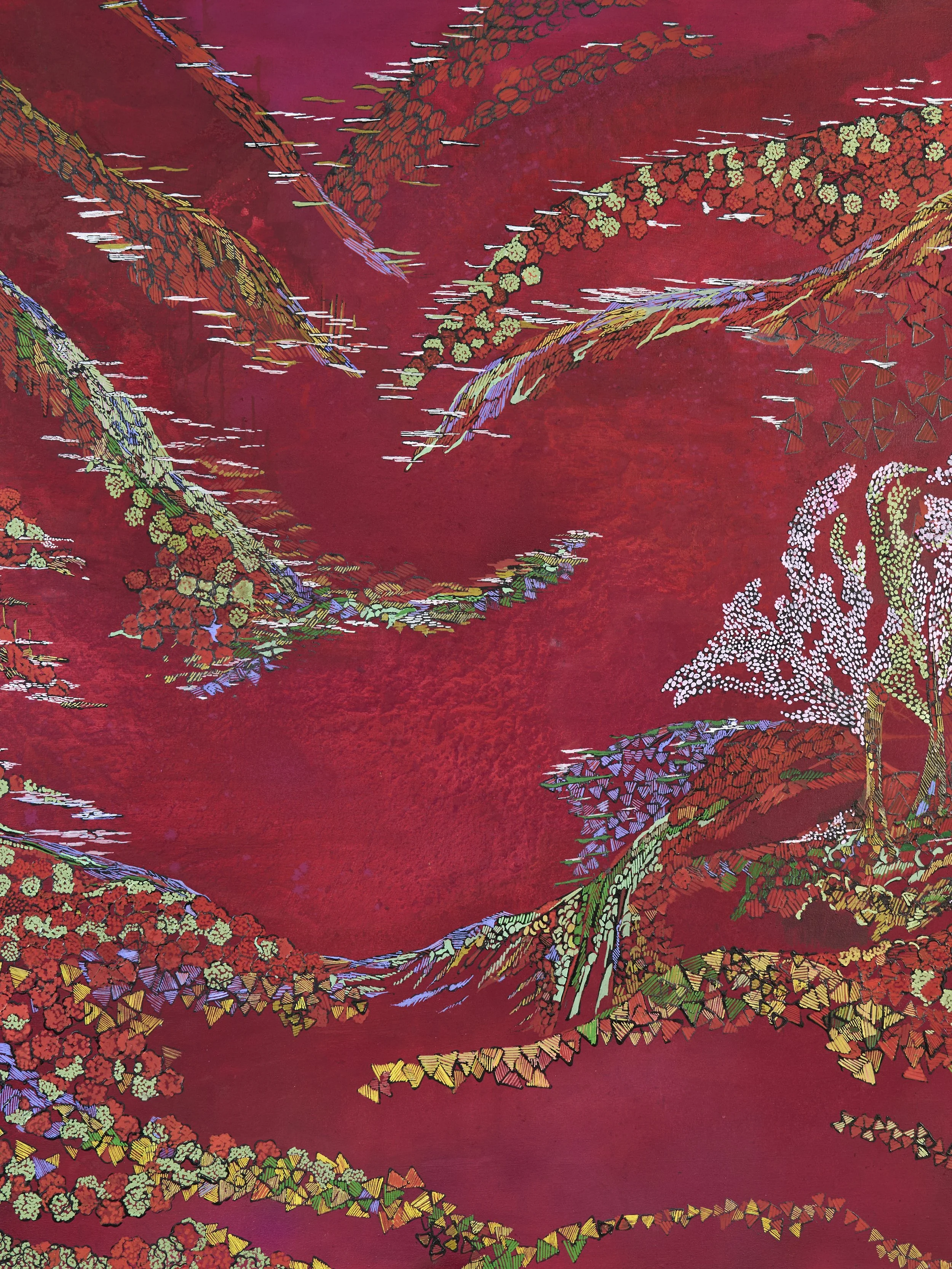 Close-up view of a colorful fabric with intricate embroidery of floral and abstract patterns on a red background.