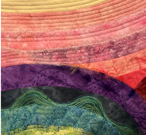 Close-up of a colorful, wavy quilt with layers in shades of pink, purple, green, blue, and yellow.