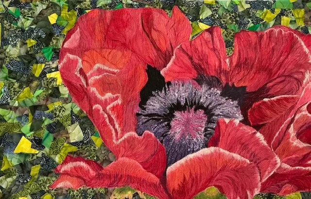A colorful collage featuring a large red poppy flower with detailed petals and a dark center, set against a background of torn paper pieces in green, yellow, and blue.