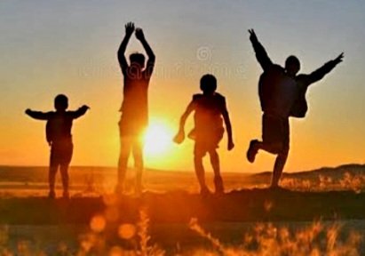 Four people jumping and celebrating at sunset on a beach.
