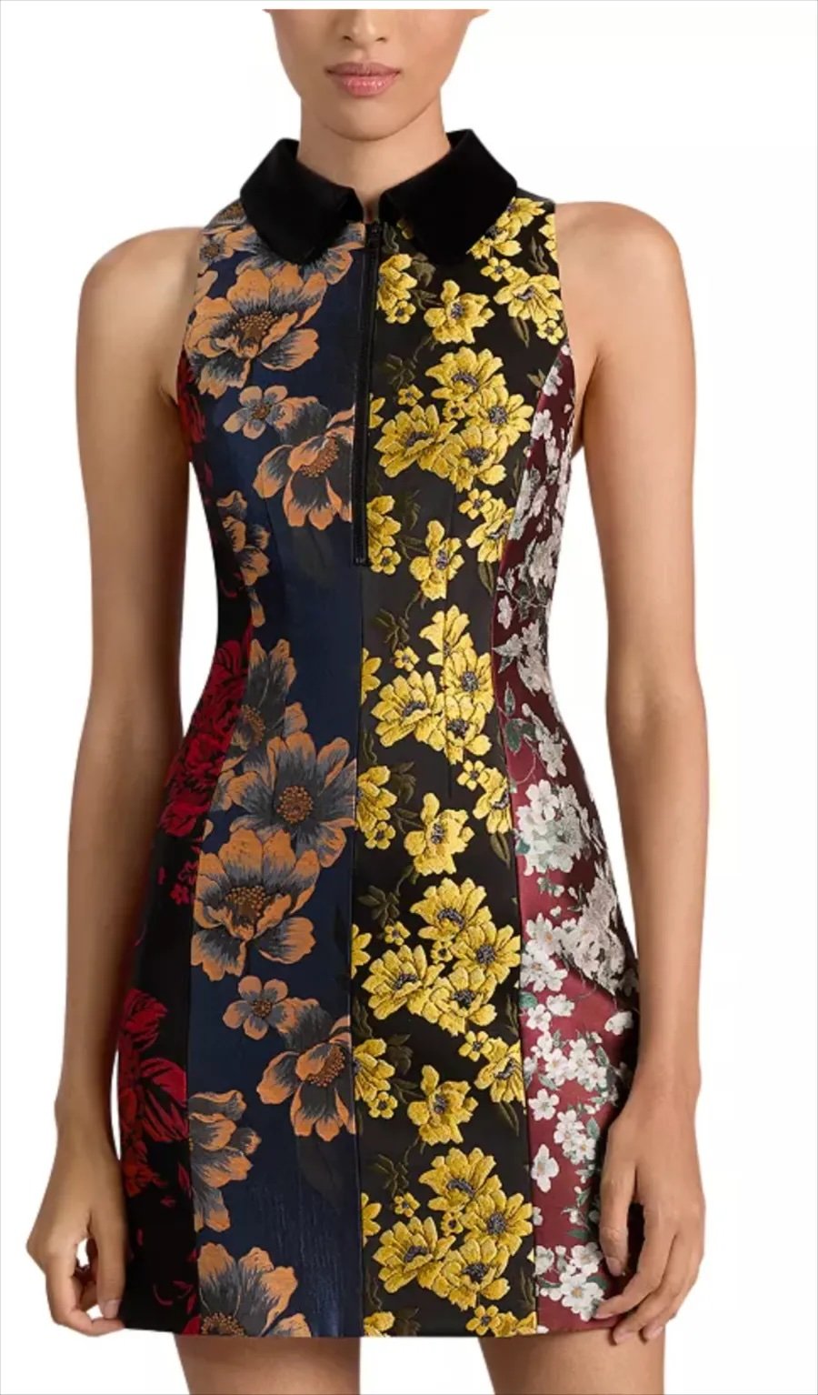 Close-up of a woman in a sleeveless dress with floral patterns in dark blue, black, and maroon, with yellow, orange, red, white, and gray flowers, featuring a black collar and zipper front.