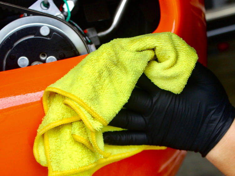 Technician wiping down a PA-46 with microfiber during an aircraft dry wash at Long Beach Airport