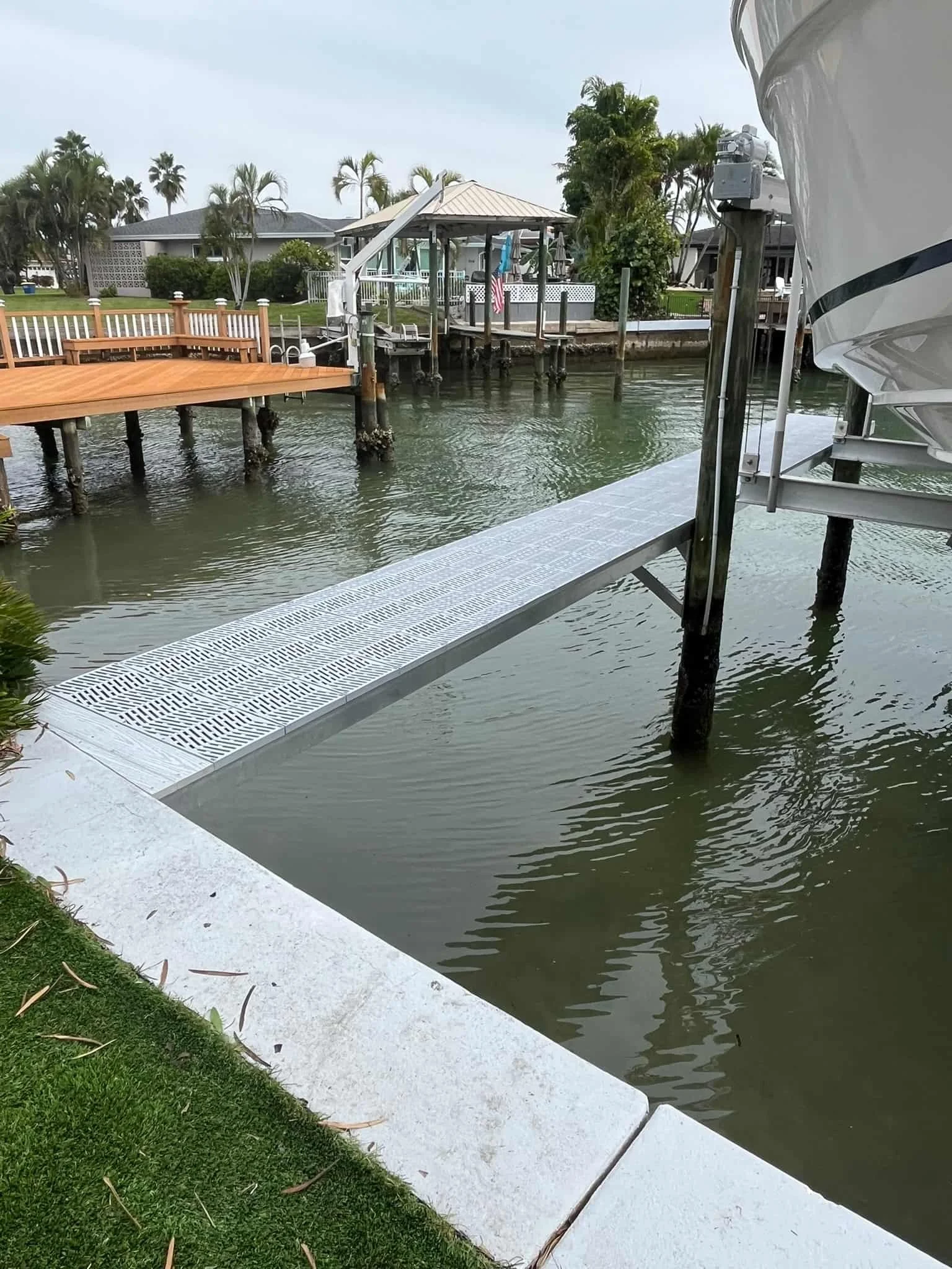 aluminum finger dock with through flow decking next to a boat lift